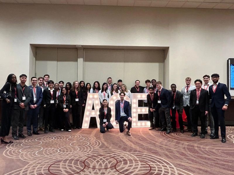 U of GH's ACE chapter poses all together with an ACE letter sign