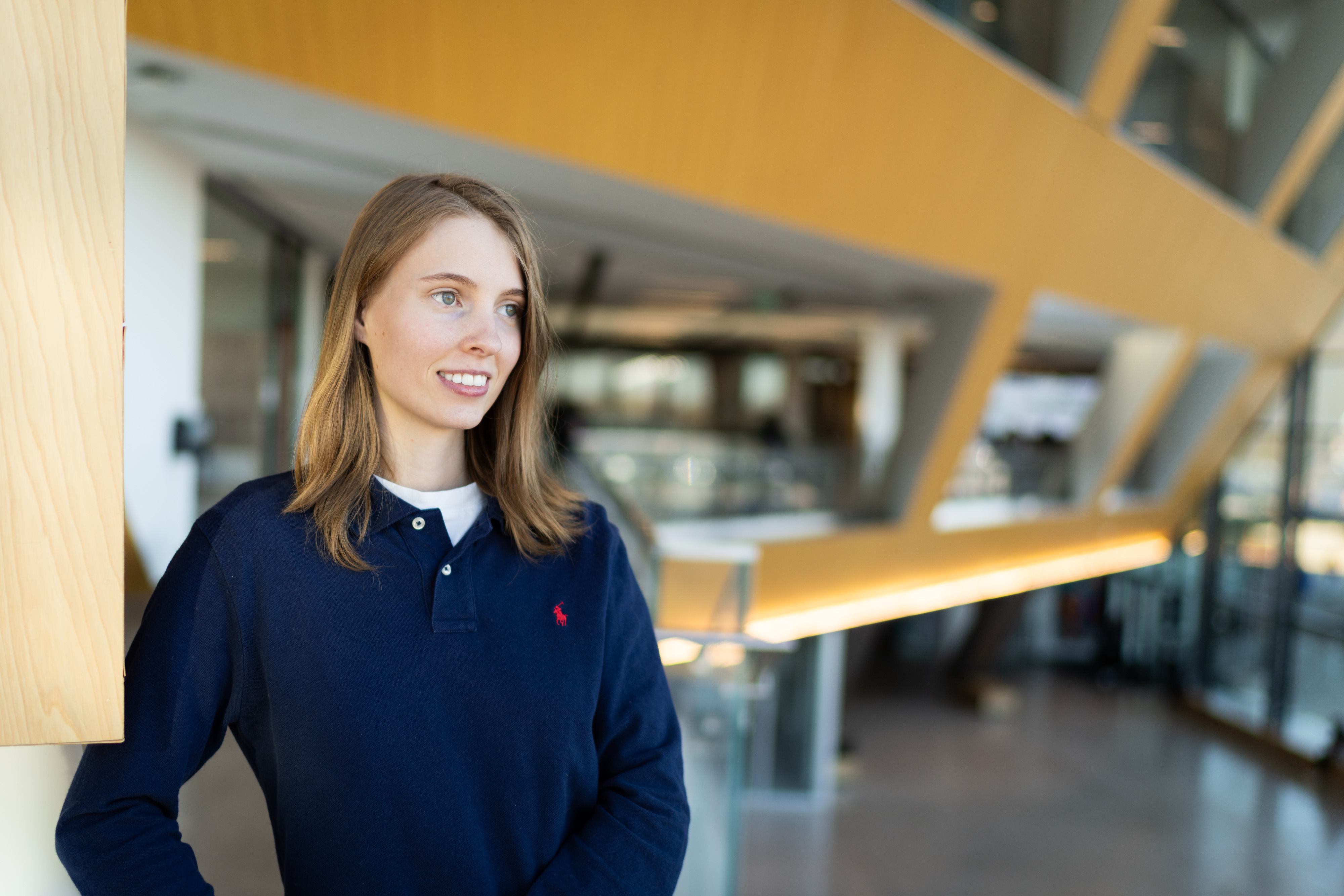 A woman, Kate Carveth, wearing a navy blue shirt poses