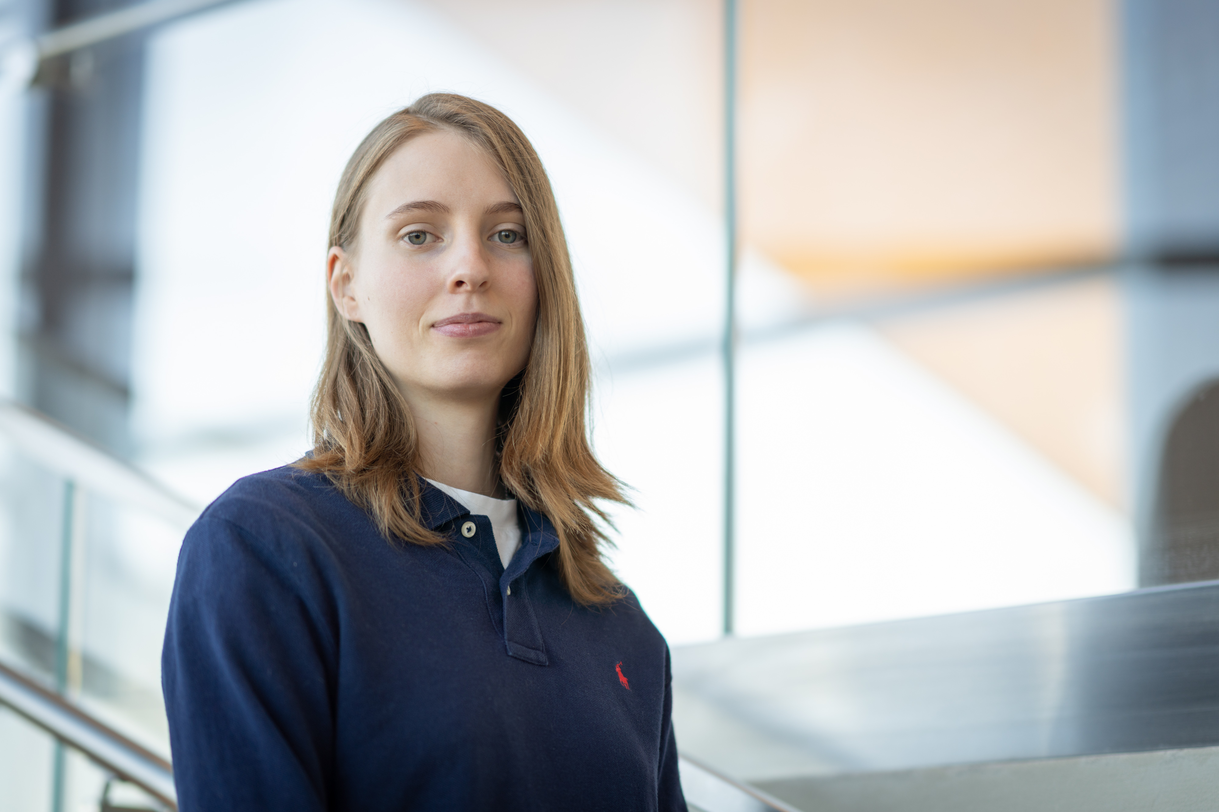 A woman, Kate Carveth, wearing a navy blue shirt poses