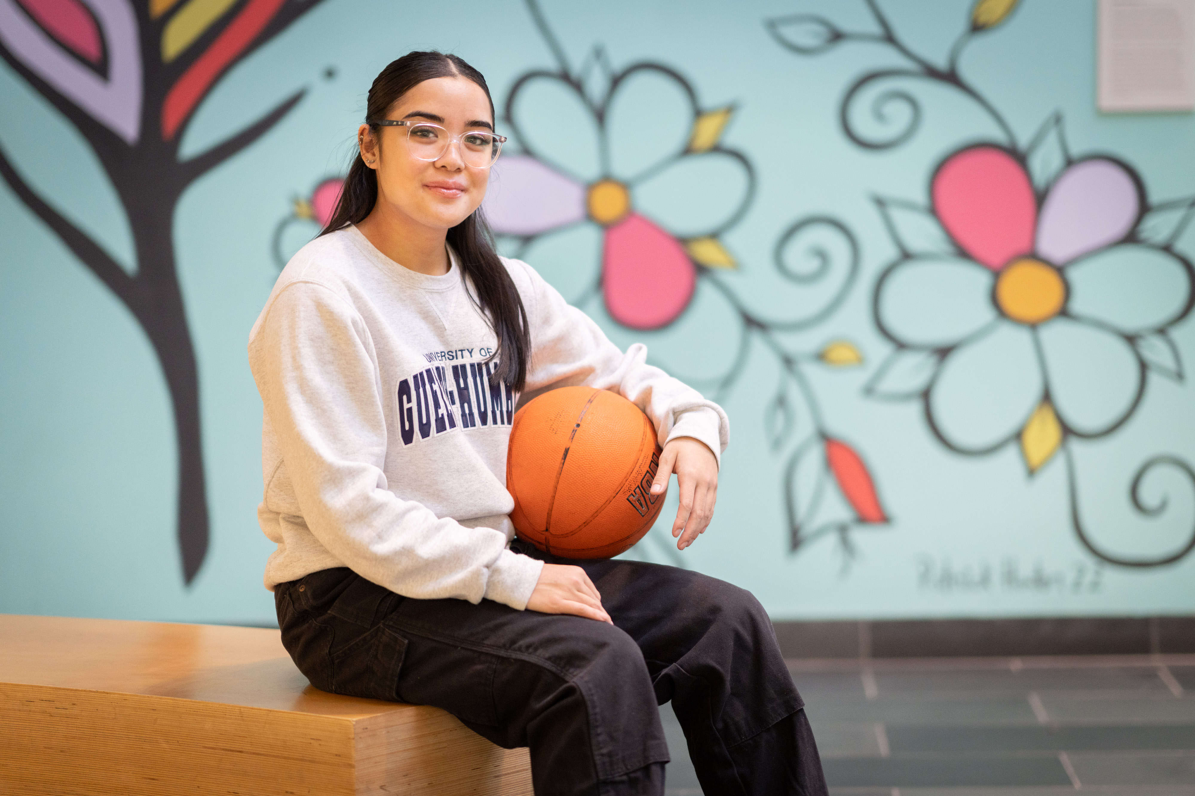 Hope sits down holding a basketball