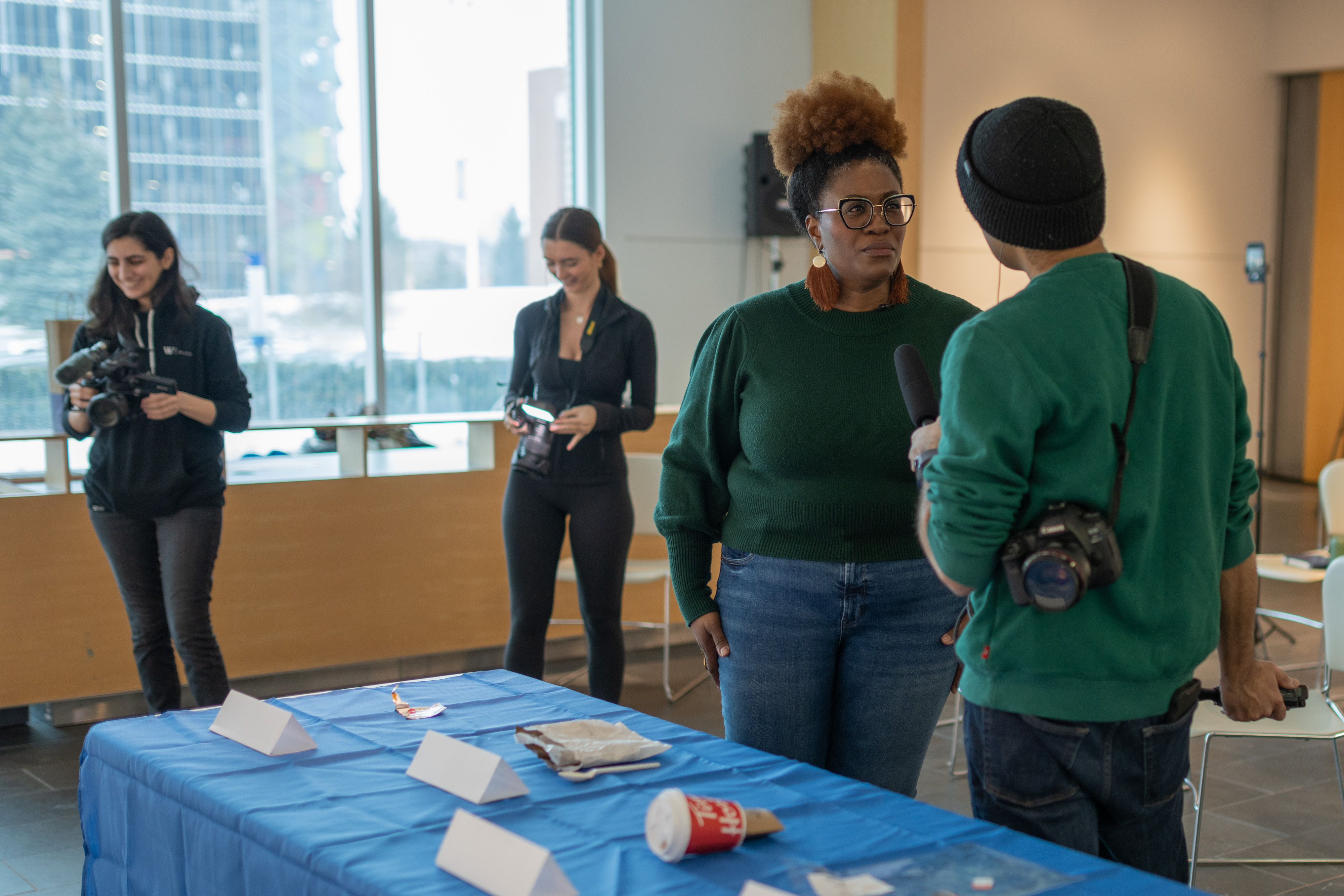 Guelph-Humber students shoot the Ecoblitz event while Zamani Ra speaks to a journalist