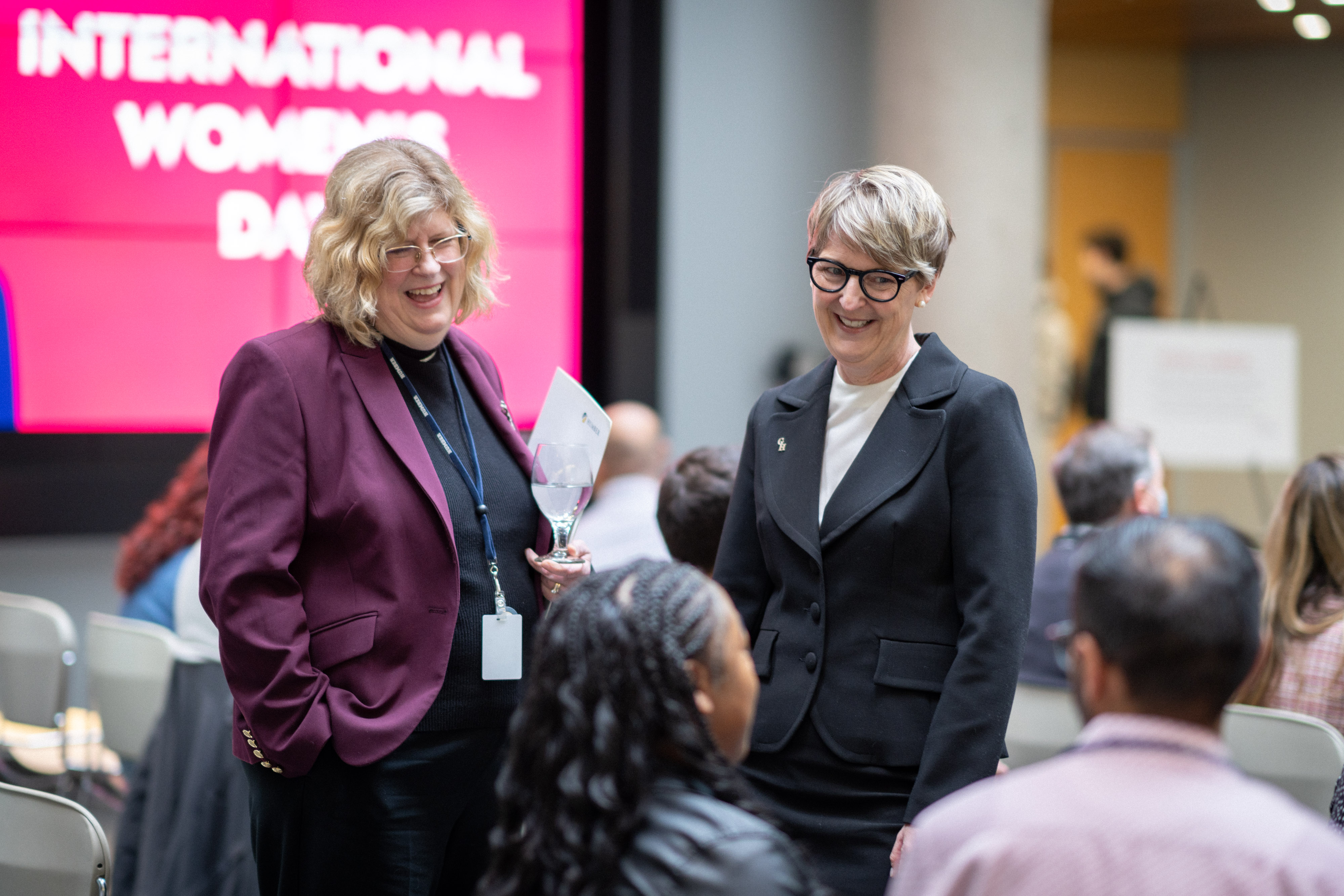 Dr. Vaughan and Dr. Spence-Ariemma talk to guests at the event, smiling