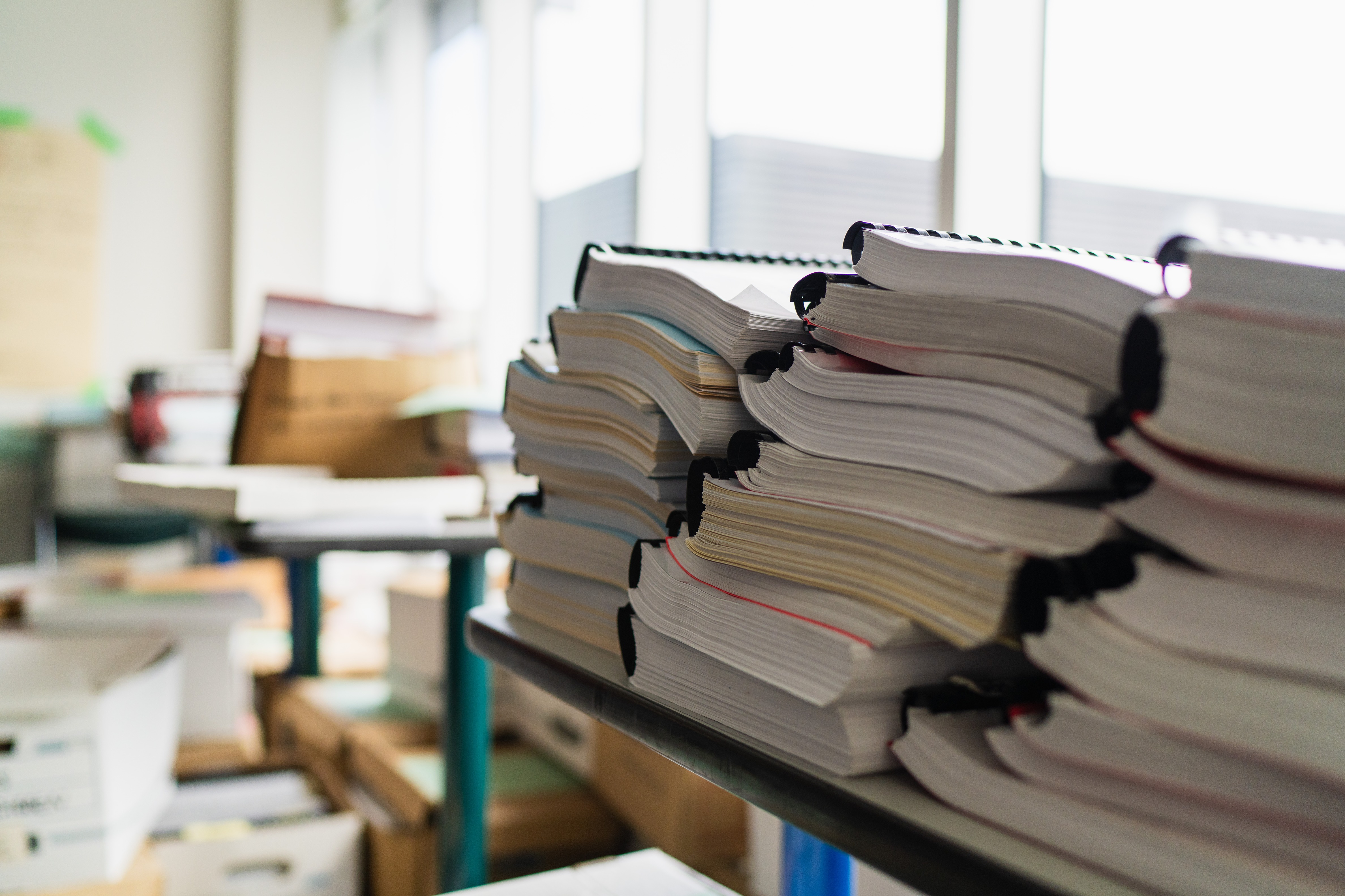 A large stack of documents on a table