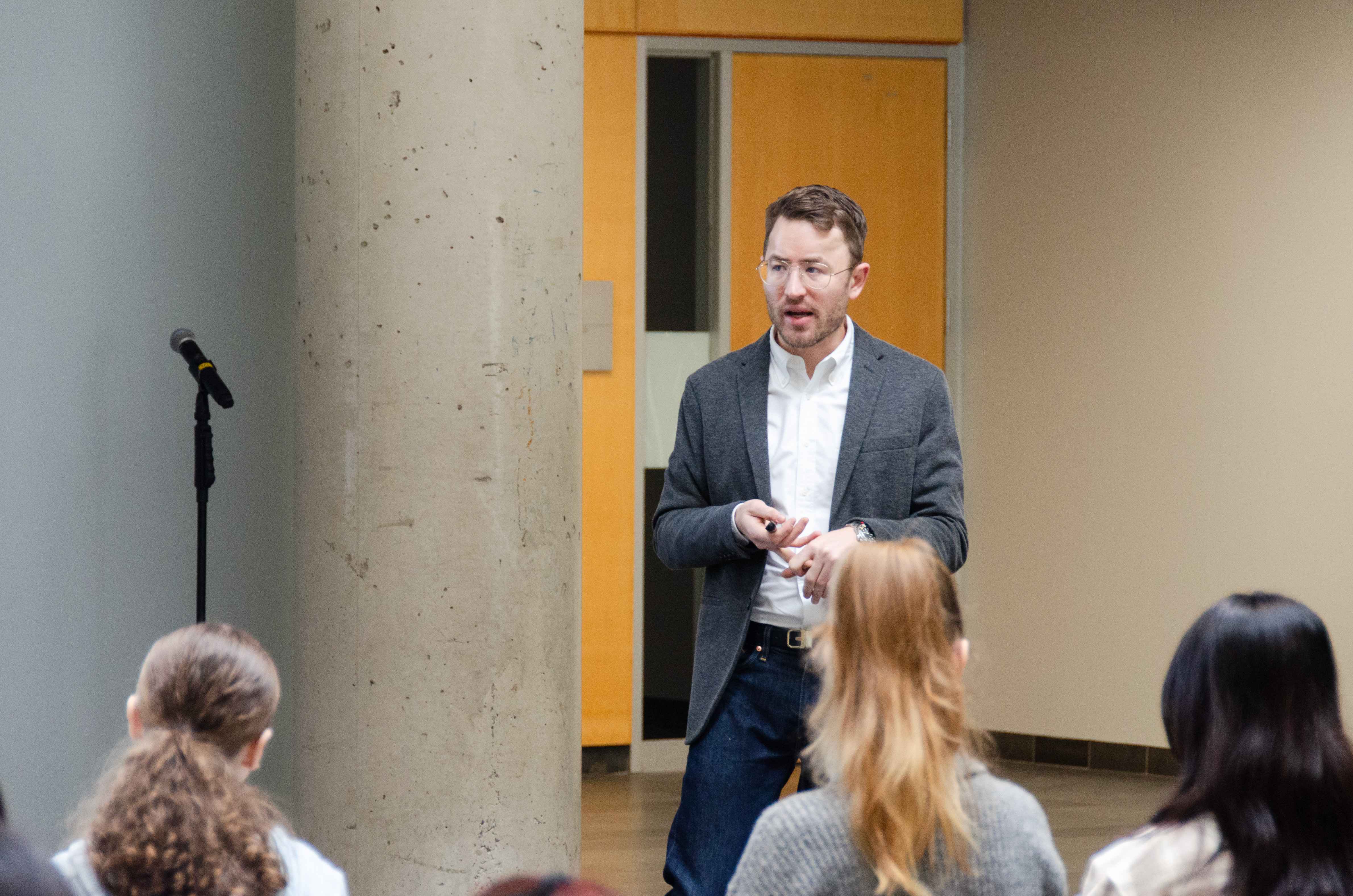 Jared Batten speaks to a group of students as they sit 