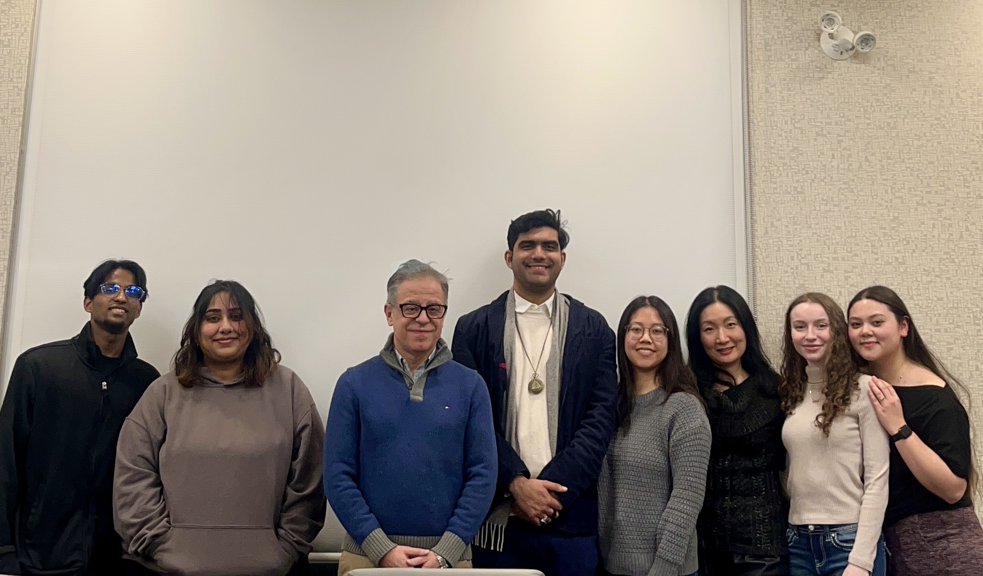 Dr. Kim and Dr. Bragues pose with six students during the Sophia Forum