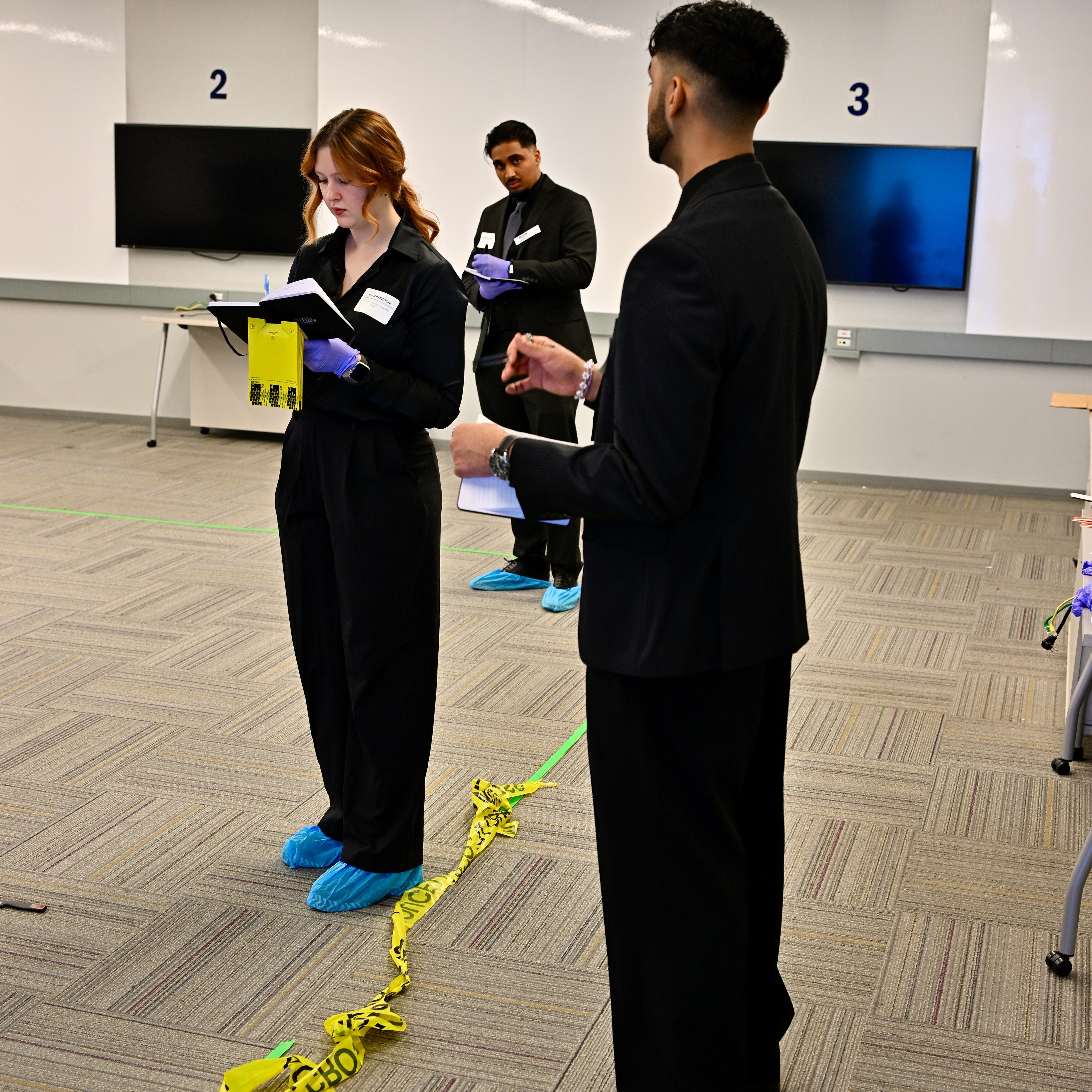 A group of three students participate in the mock crime scene investigation