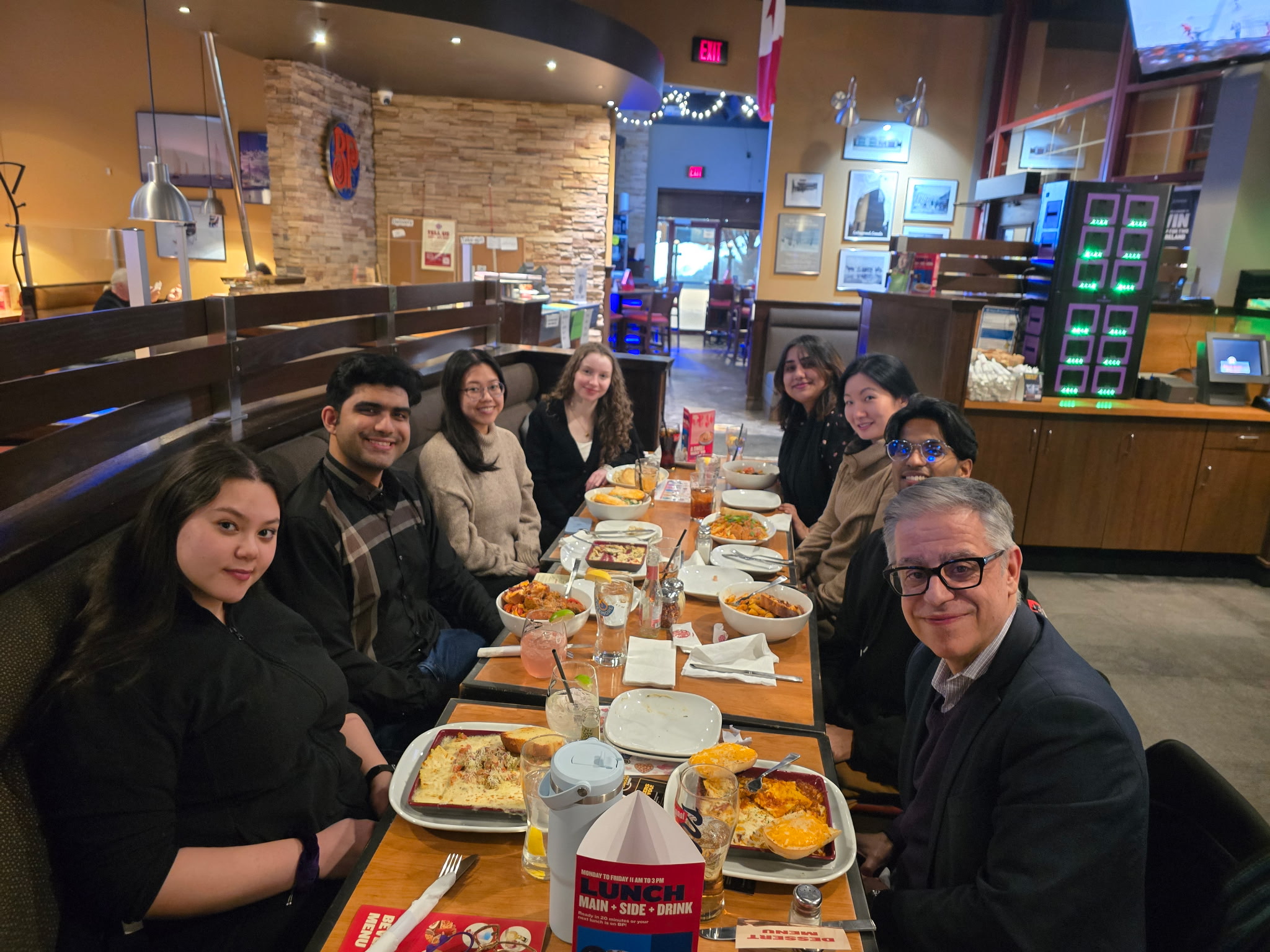 The group sits at a table eating a meal together