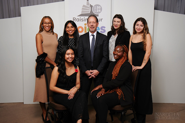 A group of seven people pose for a photo