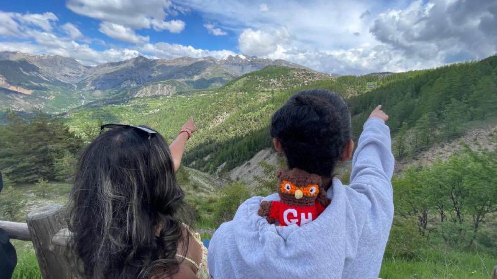 Two students pointing at mountains