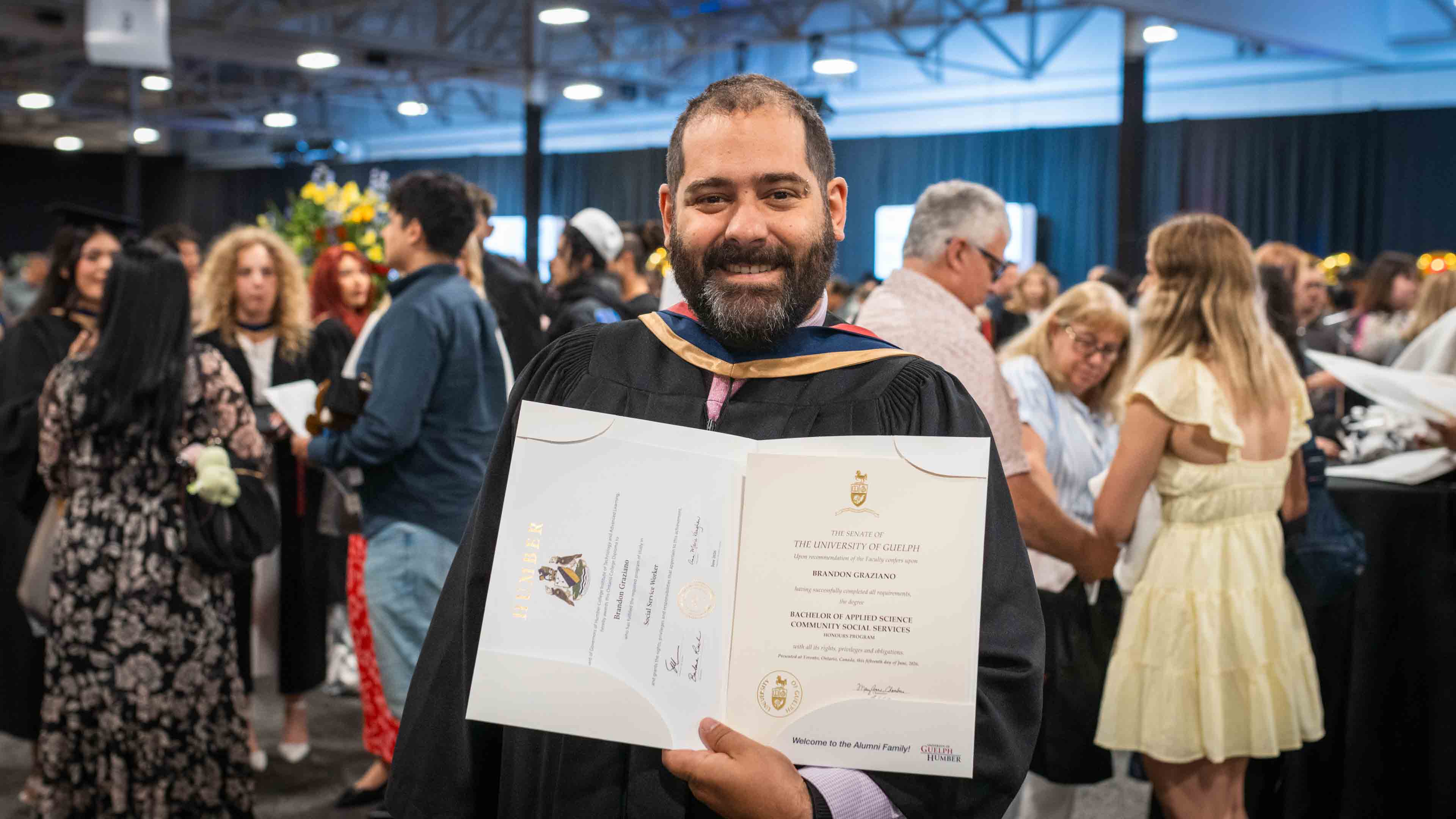 Brandon Graziano holds his parchments on convocation day