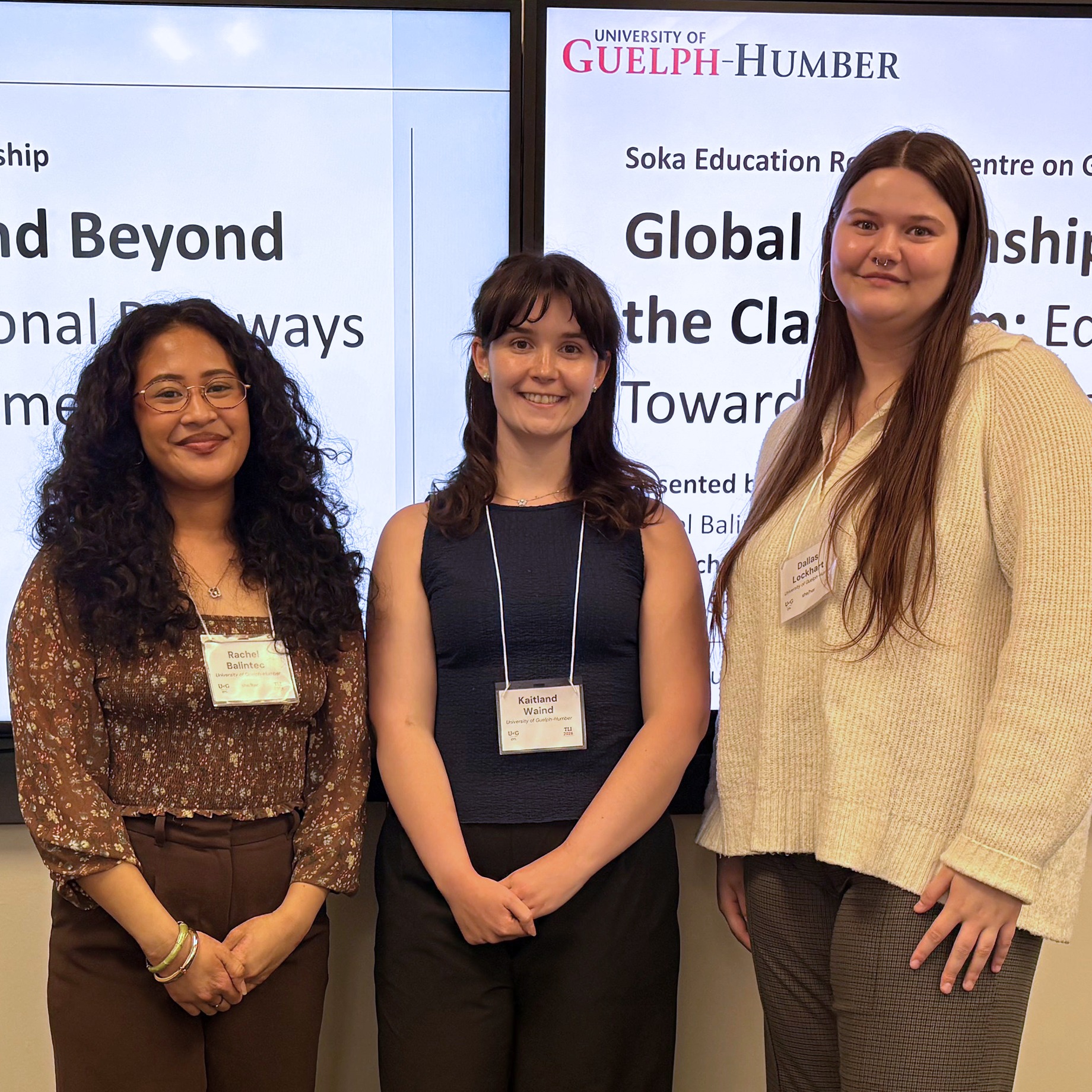 Three students stand in front of their research projected onto a screen