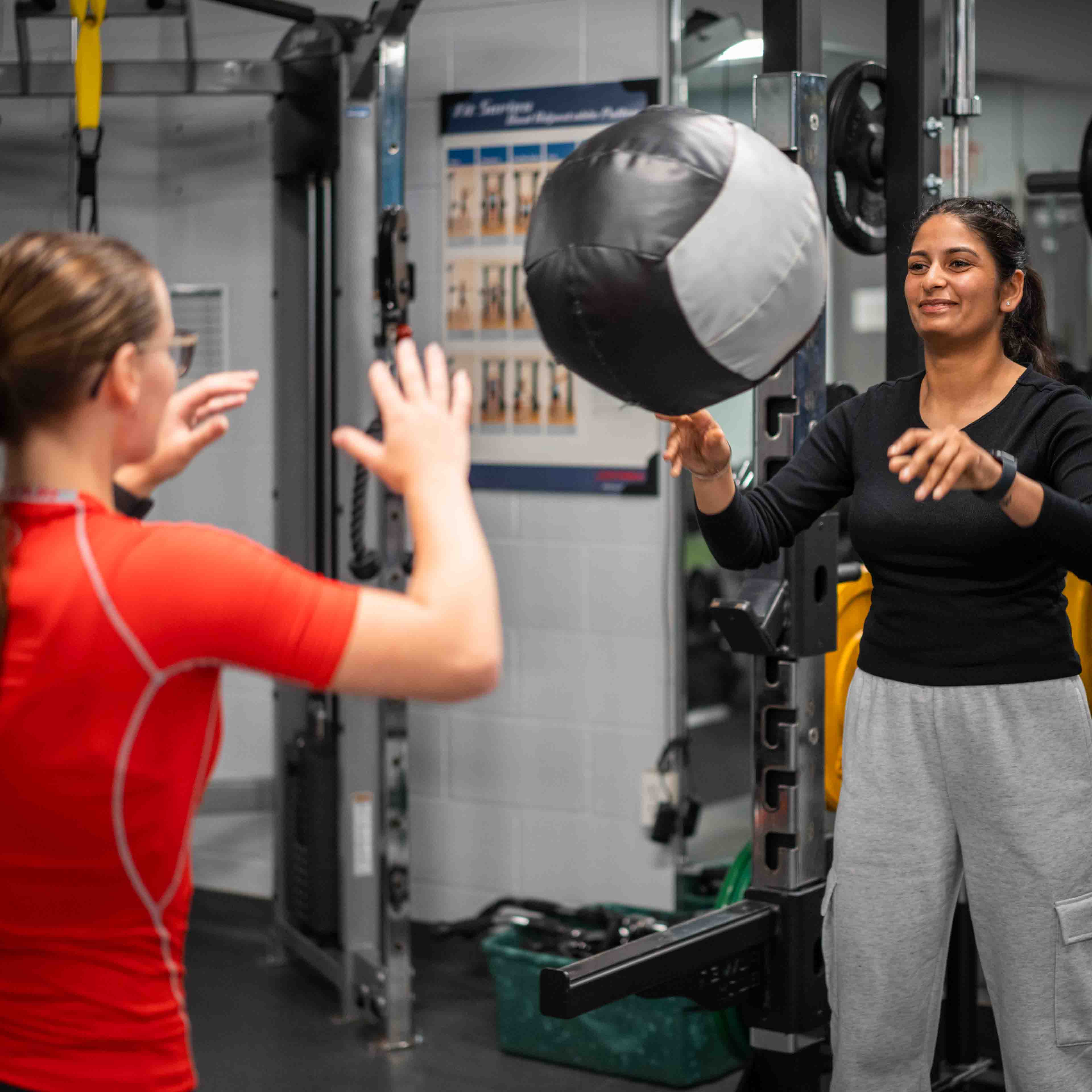 Someone throwing a ball at another person in a gym