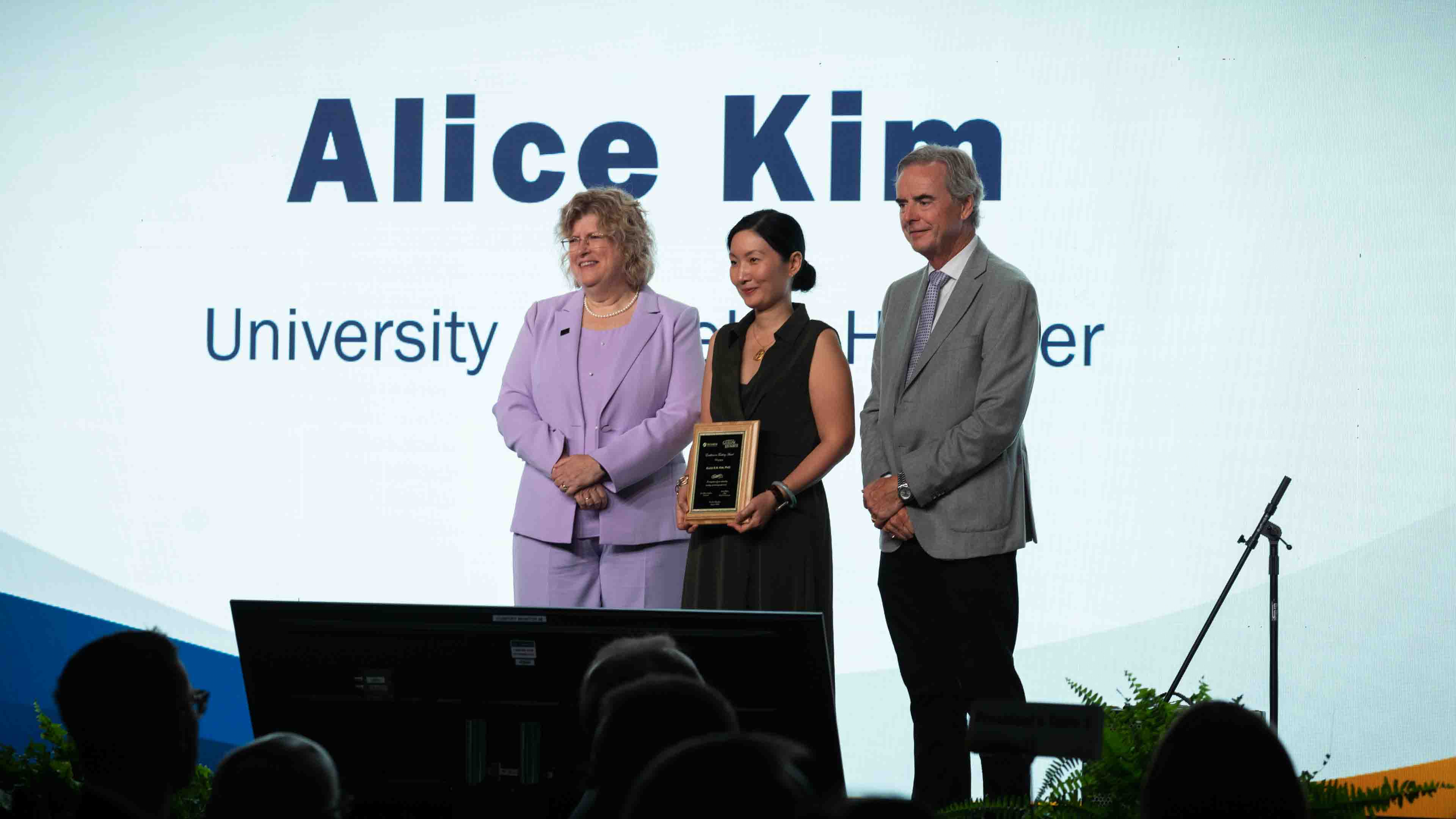 Dr. Alice Kim receives an award, standing beside two people in Humber Polytechnic leadership roles