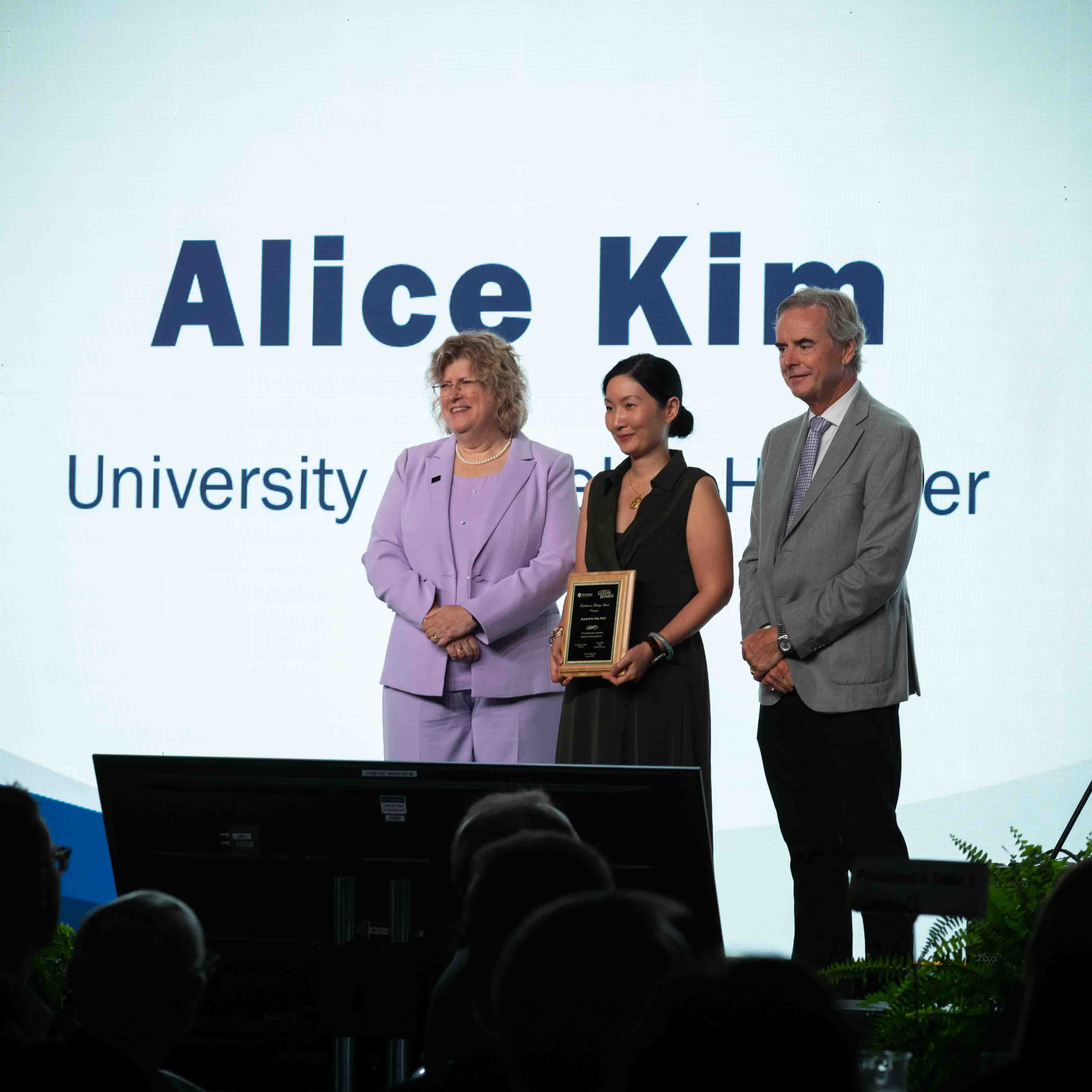 Dr. Alice Kim receives an award, standing beside two people in Humber Polytechnic leadership roles