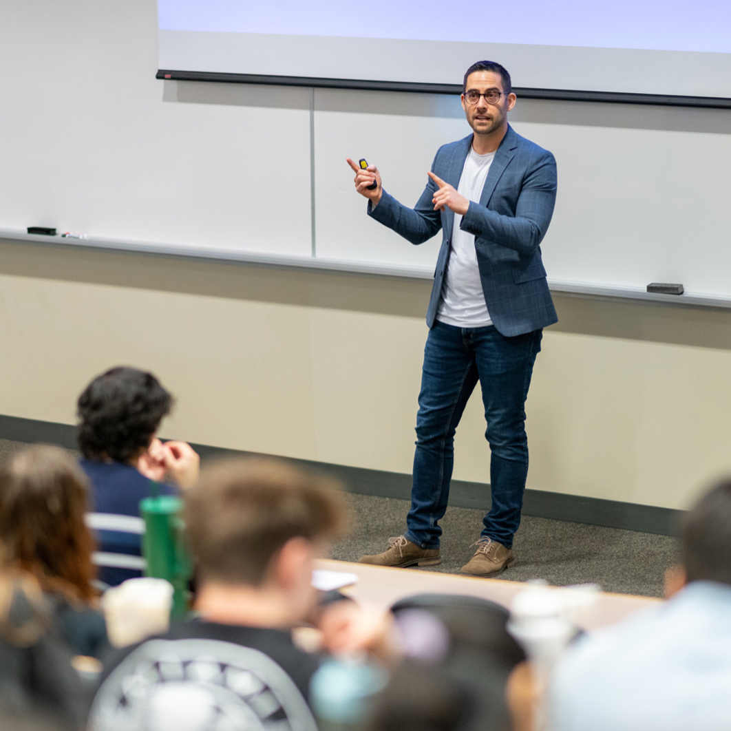 Joseph Gibbons standing at the front of a classroom lecturing students