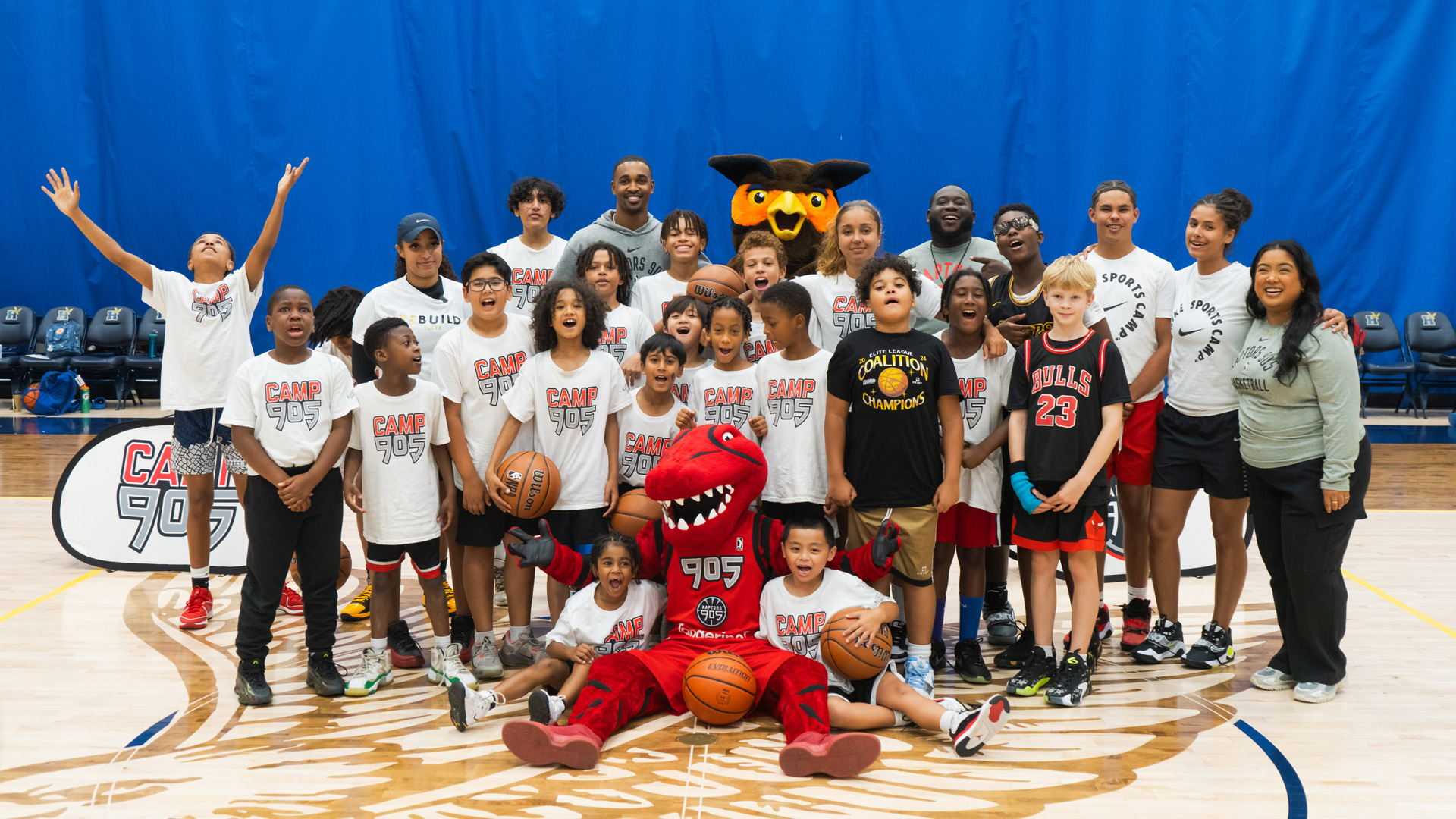 Children attending Camp 905 posing with camp counsellors and mascots