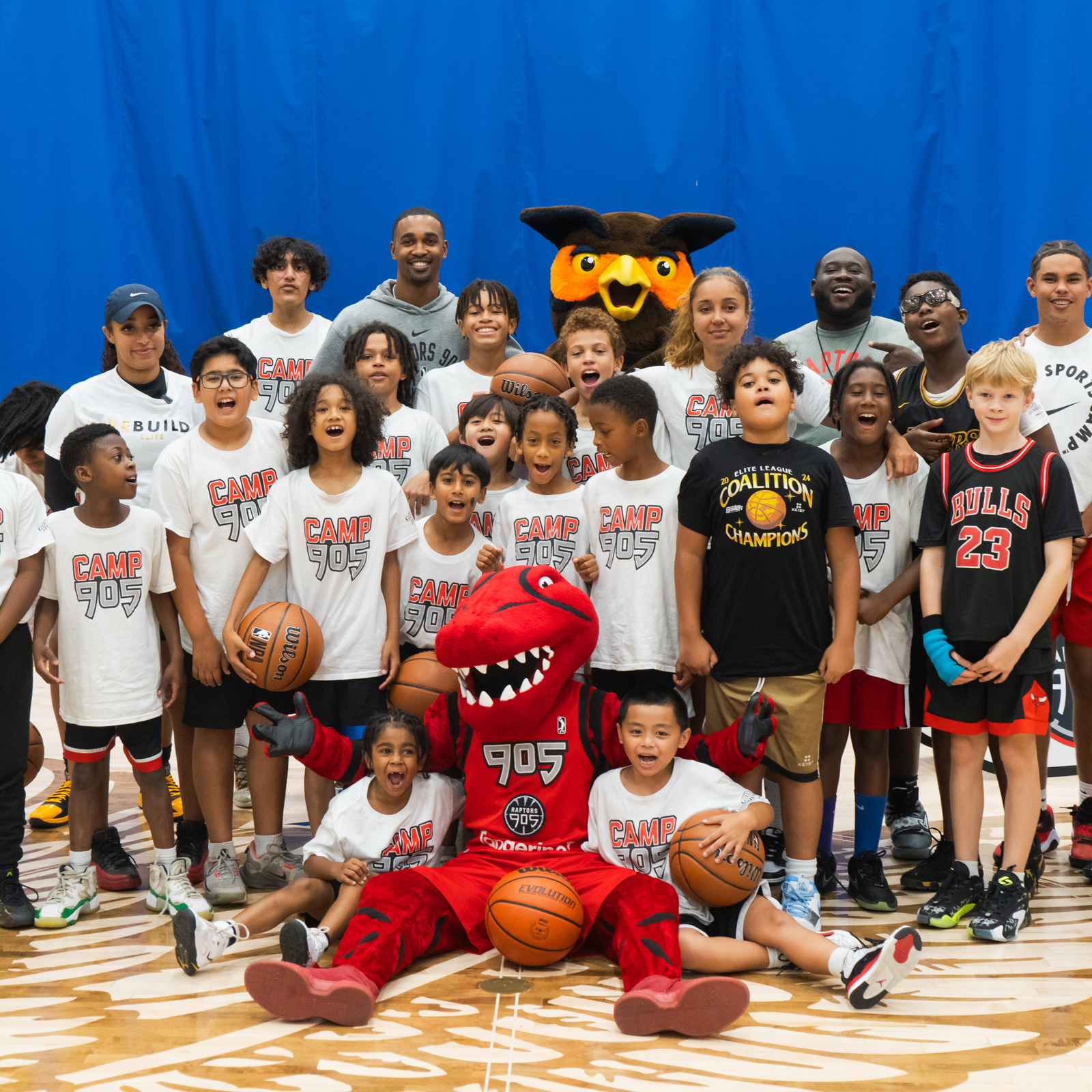 Children attending Camp 905 posing with camp counsellors and mascots