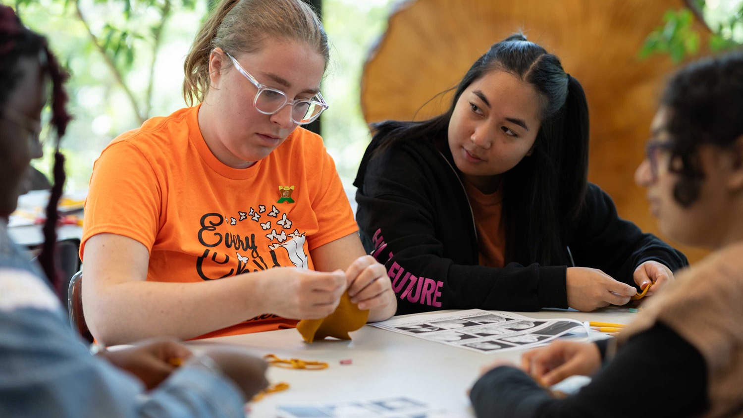 Students hand crafting moccasins