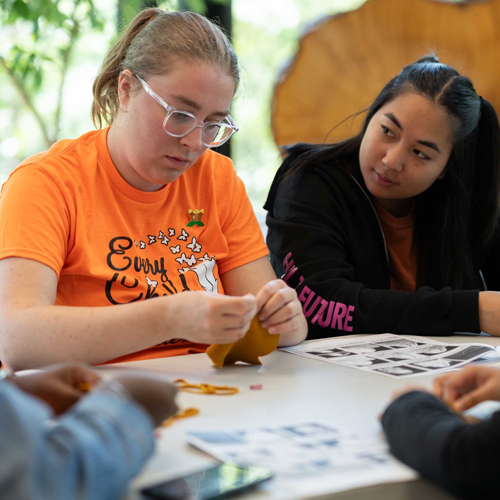 Students hand crafting moccasins