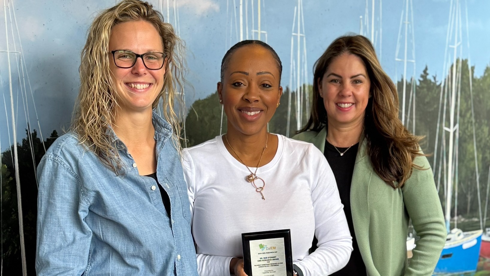 Three people posing with an award plaque