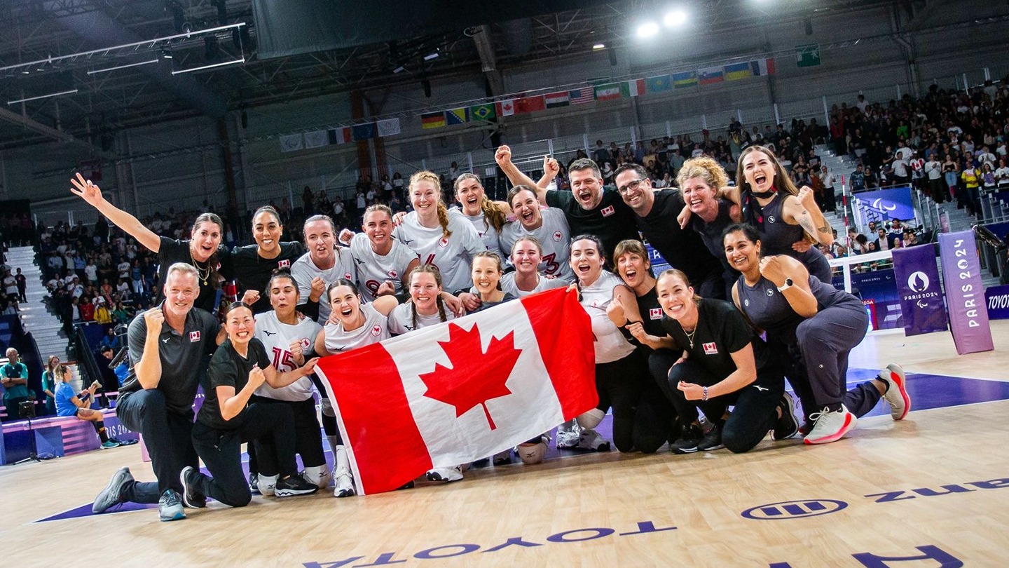 The team holds a Canadian flag at the Paris Paralympics