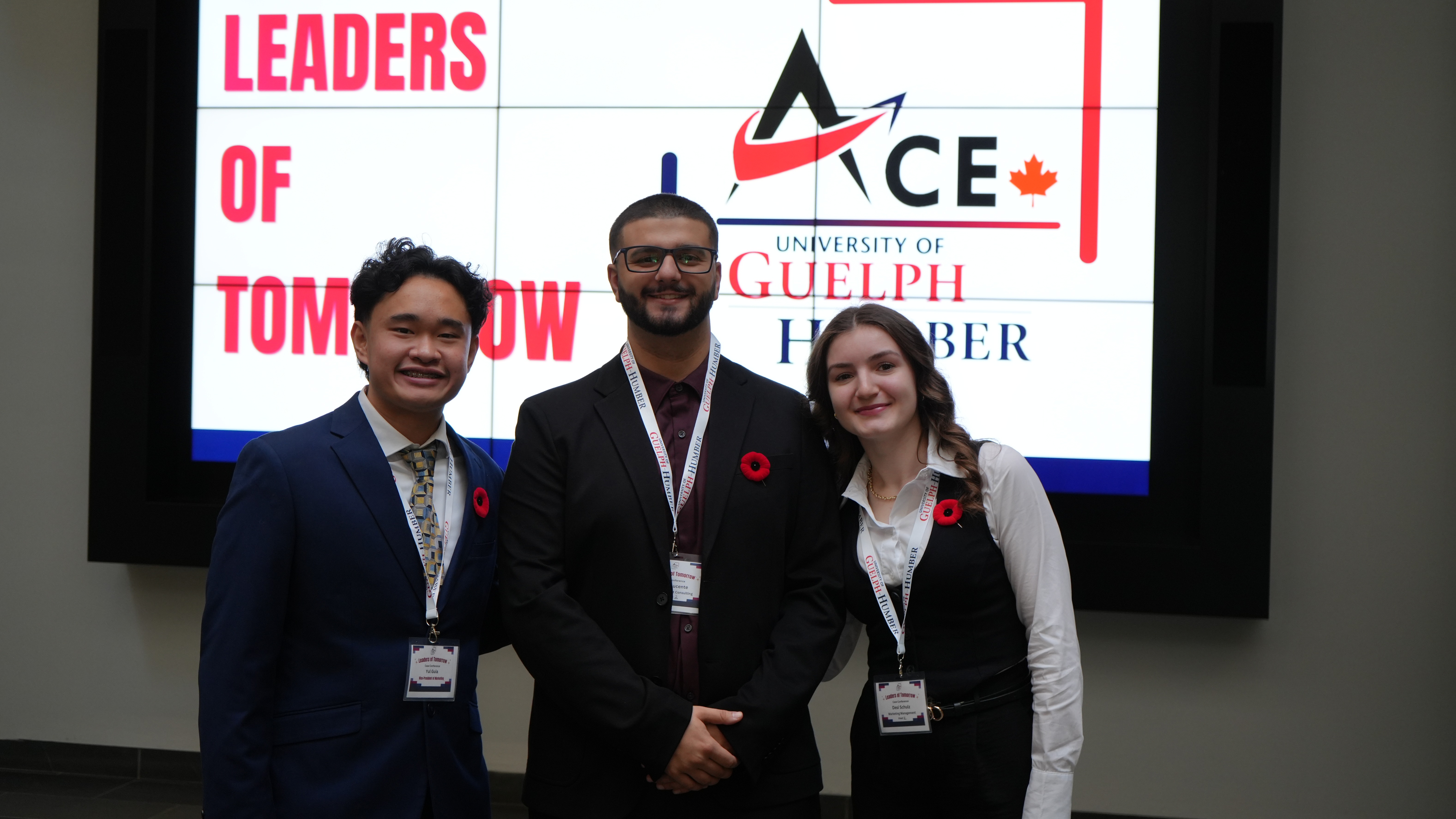 A group of three people pose in front of a screen that says Leaders of Tomorrow ACE Guelph-Humber