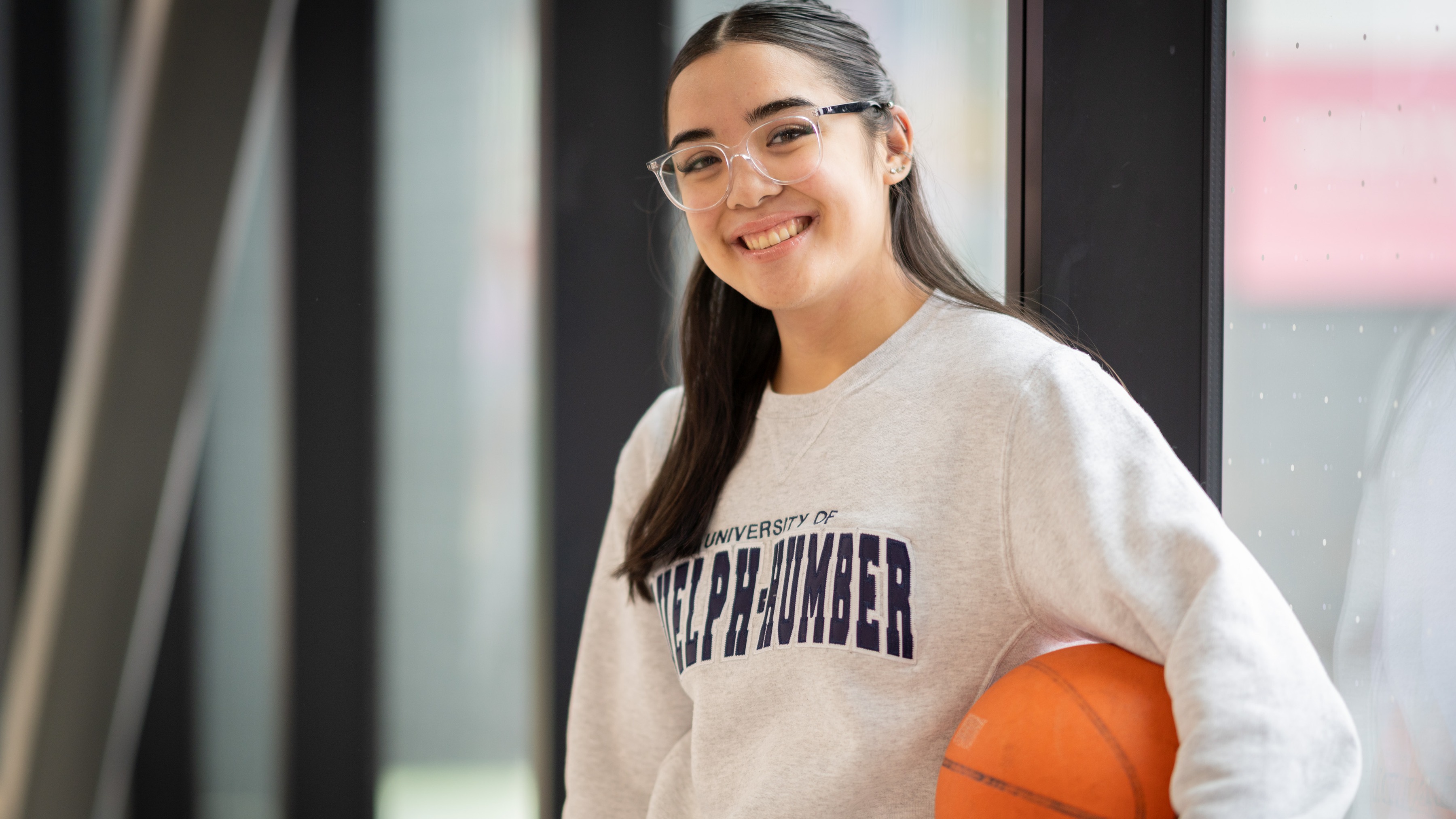 Hope stands holding a basketball under her arm