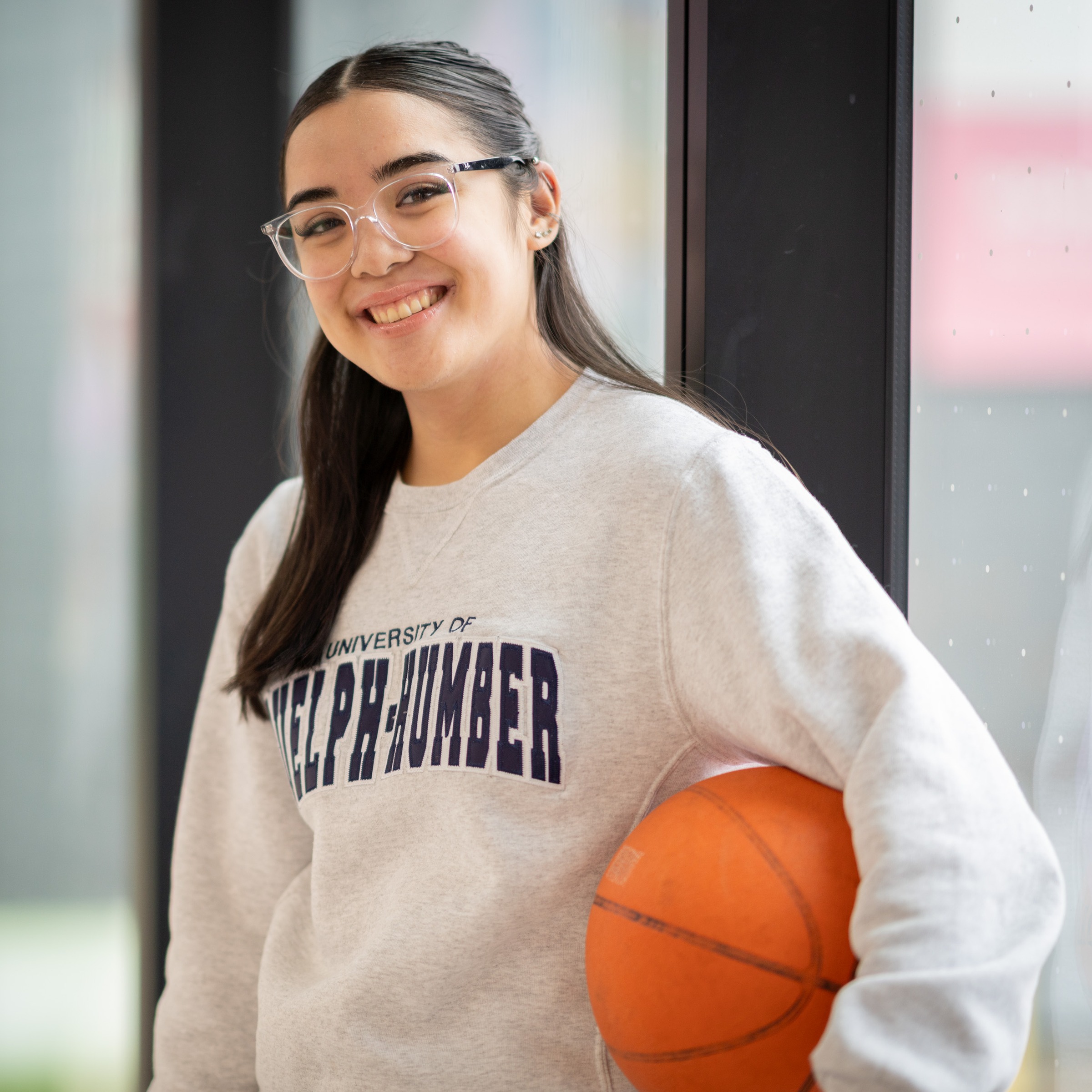 Hope stands holding a basketball under her arm