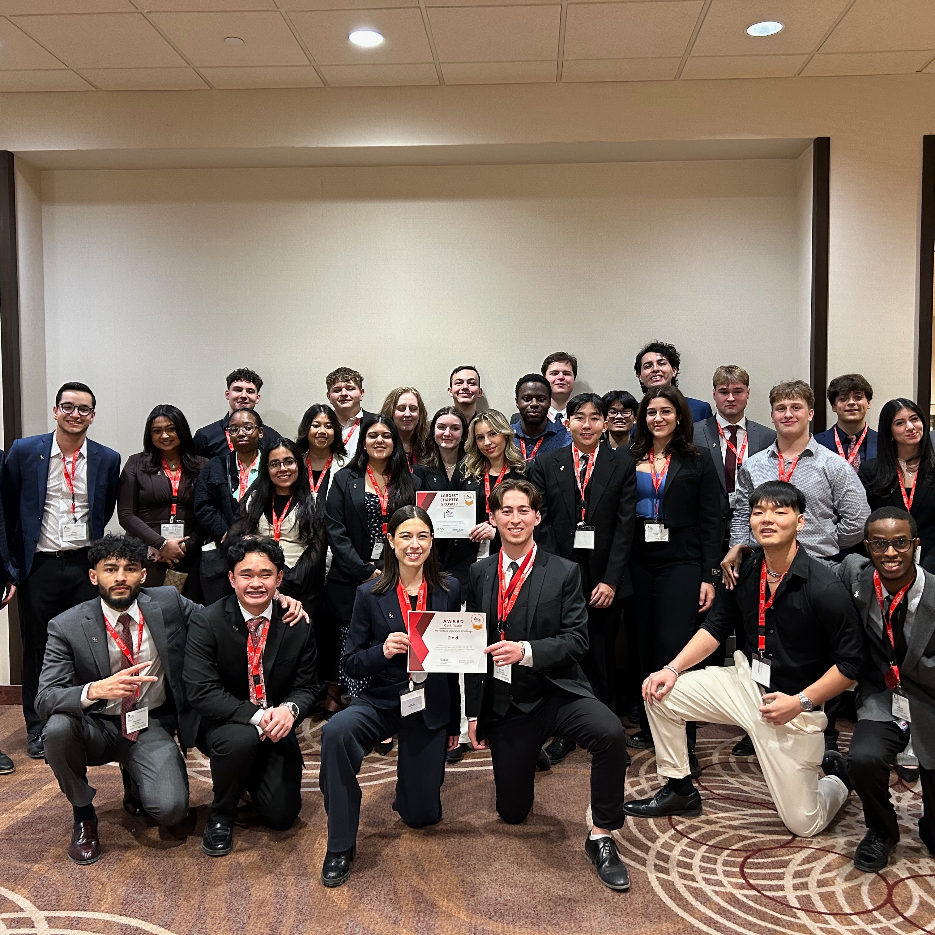 A large group of U of GH ACE students pose together with their winning certificates