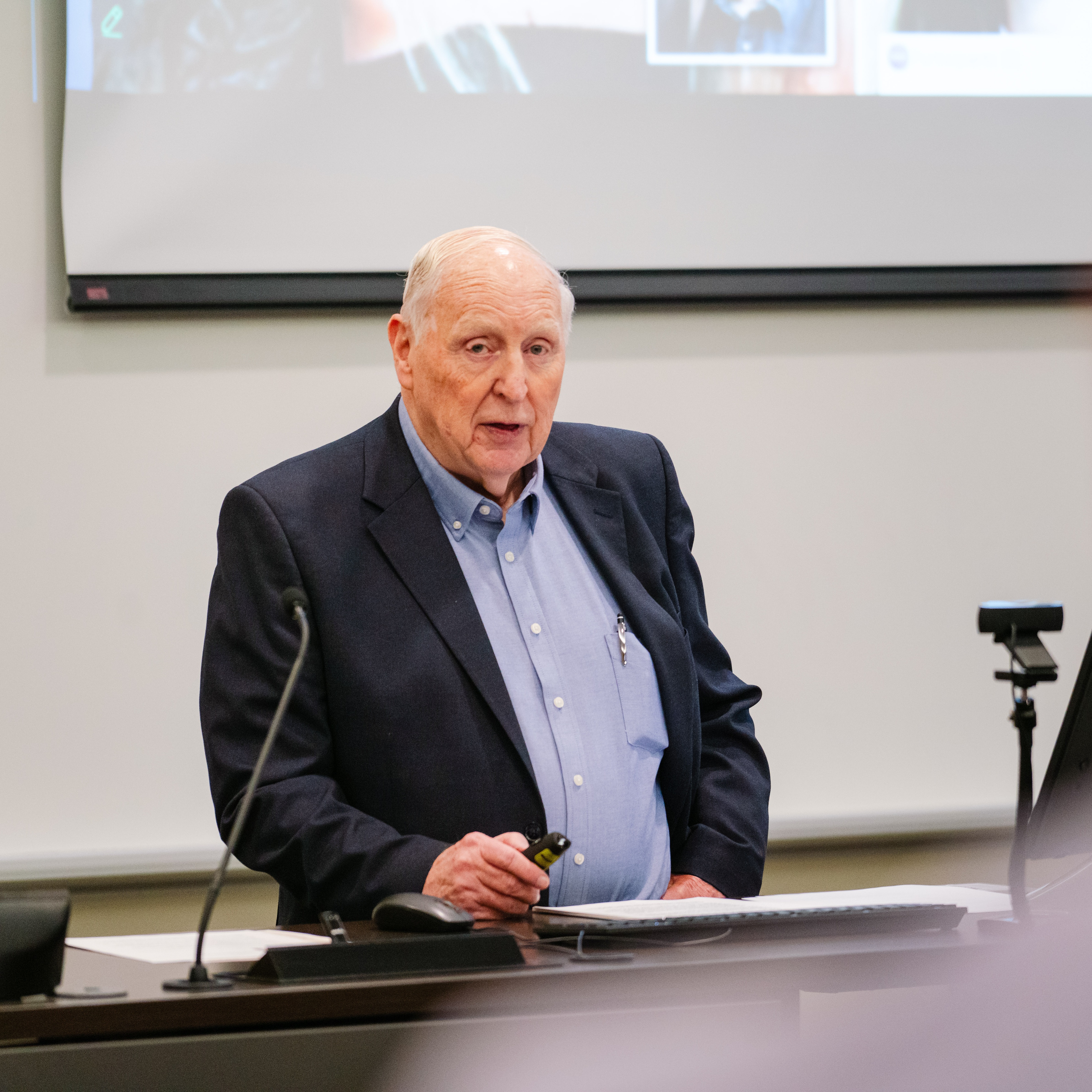 Cal Millar speaks while standing at the front of a lecture hall