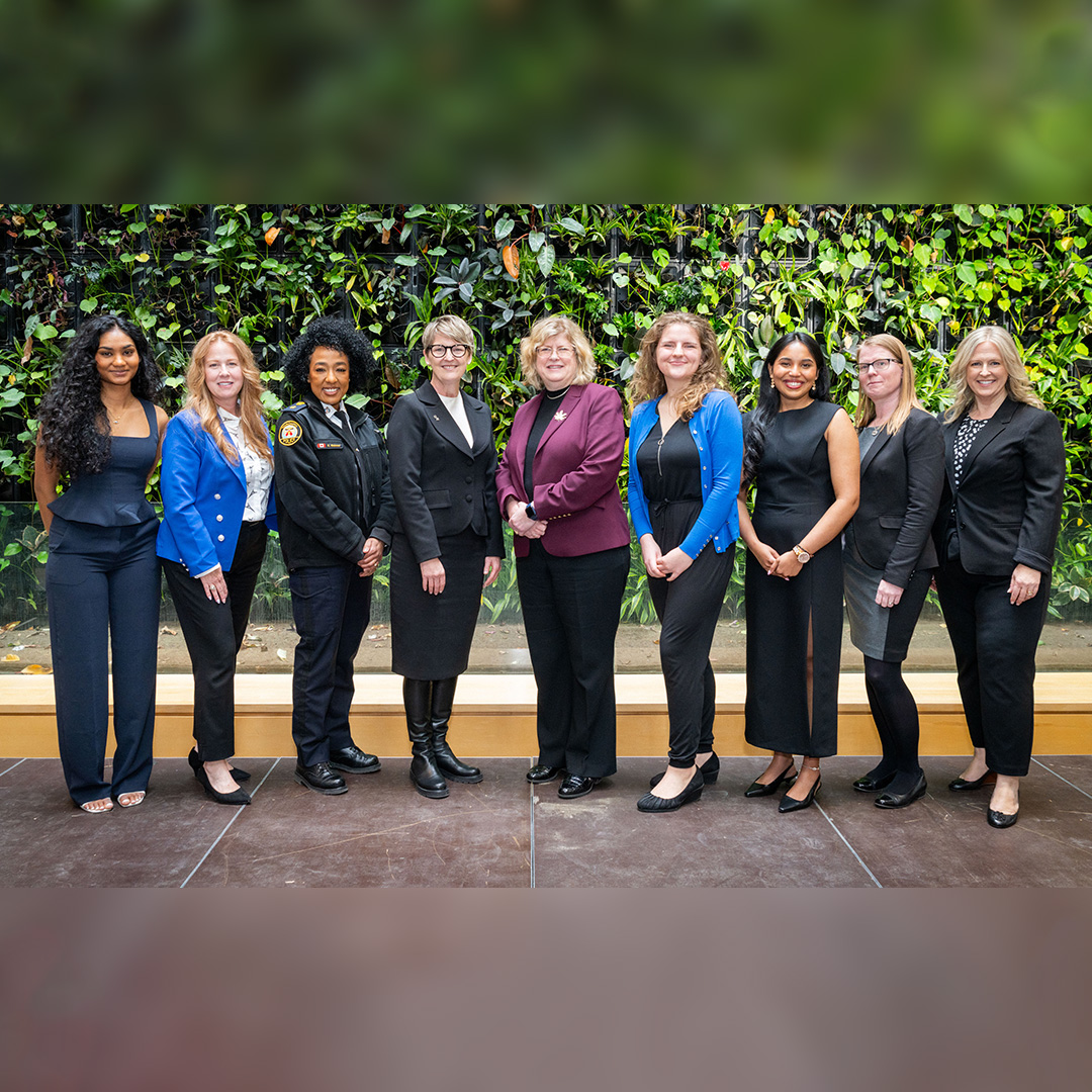 Women of Distinction recipients, moderator Naisha Suthaharan, and Dr. Melanie Spence-Ariemma and Dr. Ann Marie Vaughan stand in front of the living plant wall