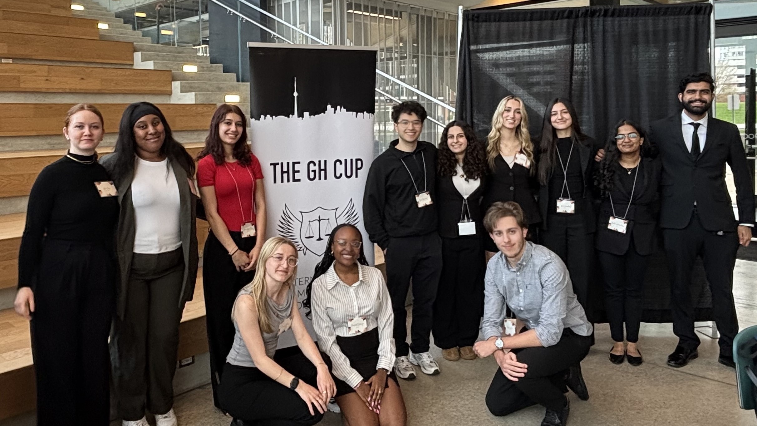The Guelph-Humber Pre-Law Society poses by a banner and stairs