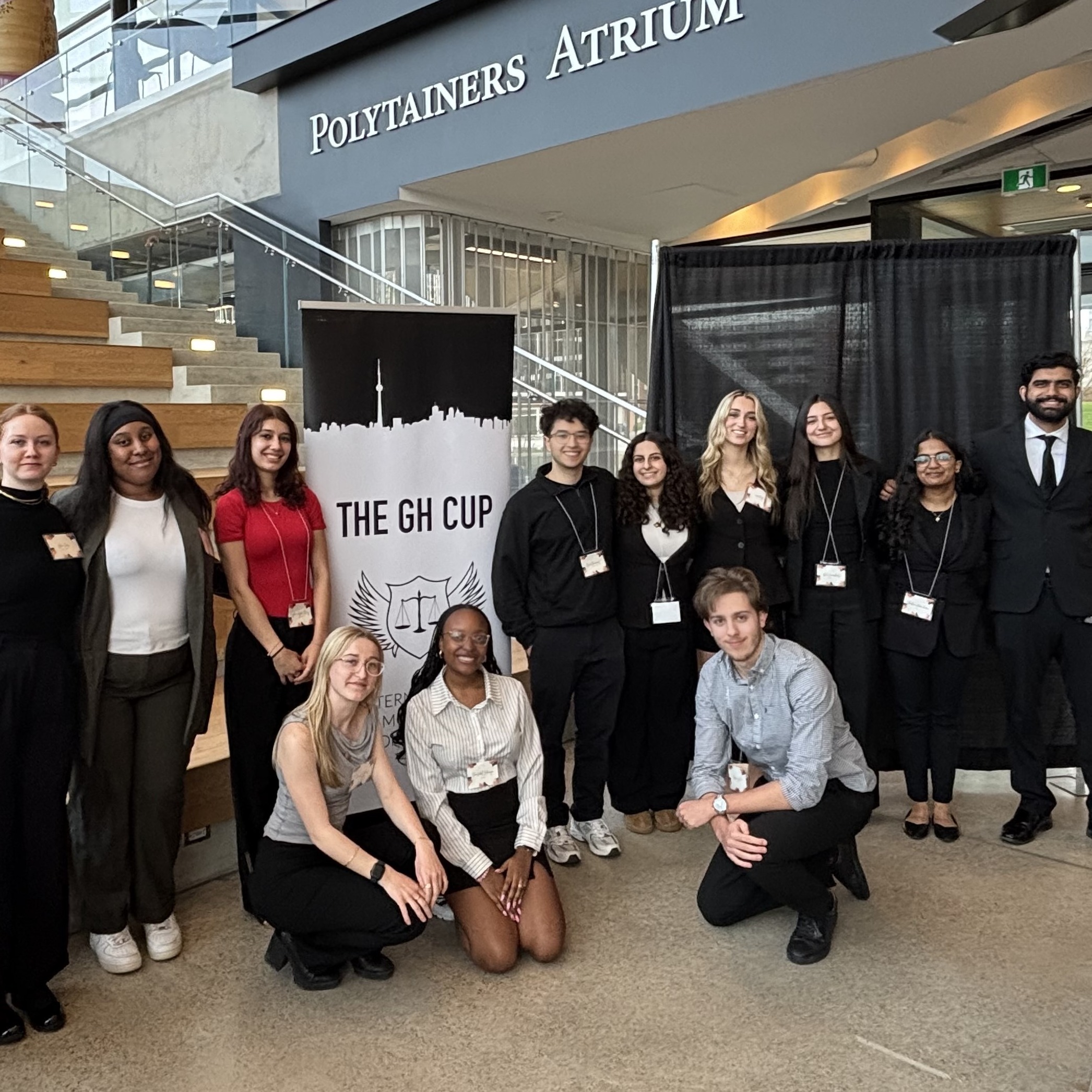The Guelph-Humber Pre-Law Society poses by a banner and stairs