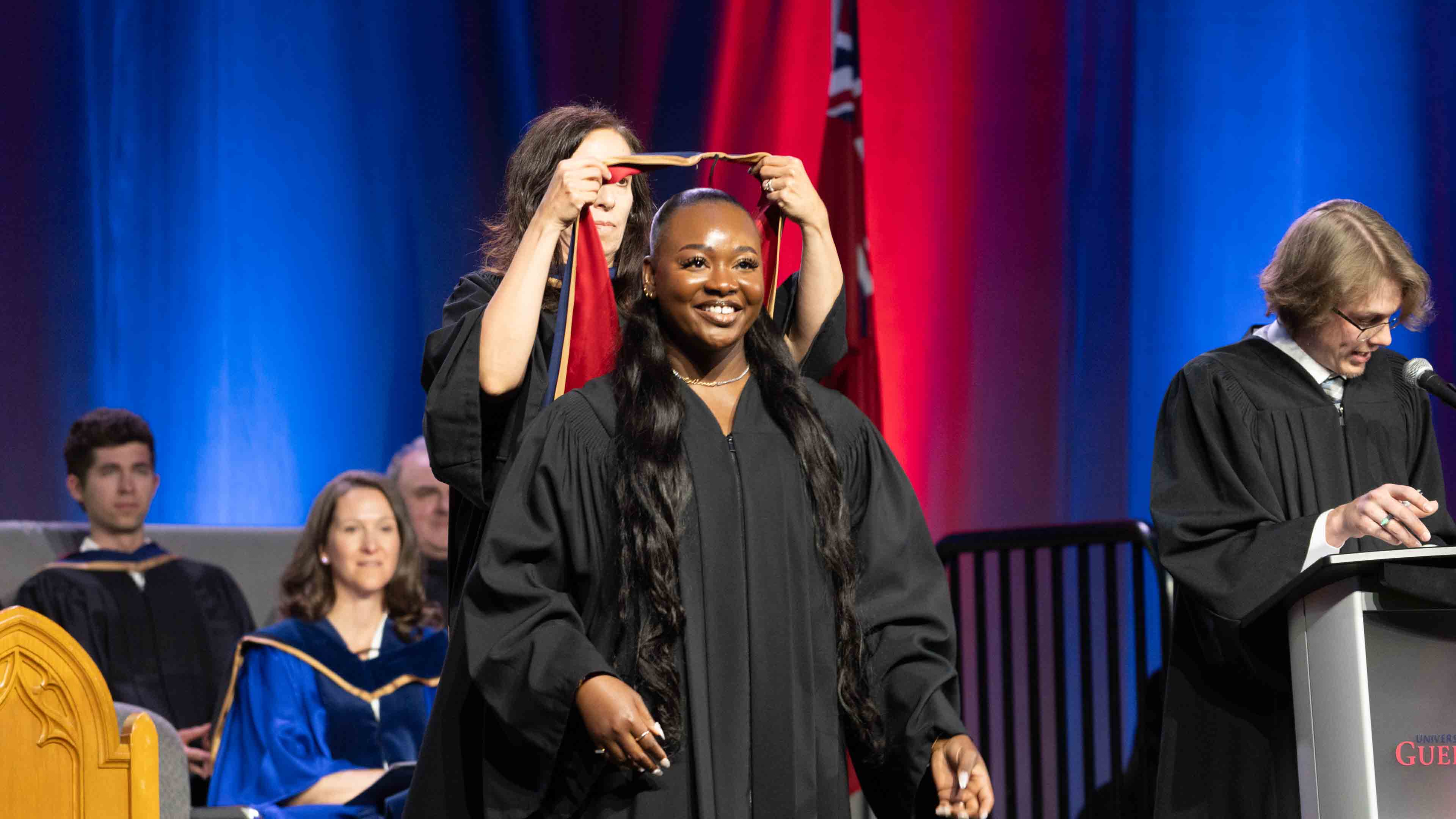 Nathania receives her graduation hood on stage at convocation