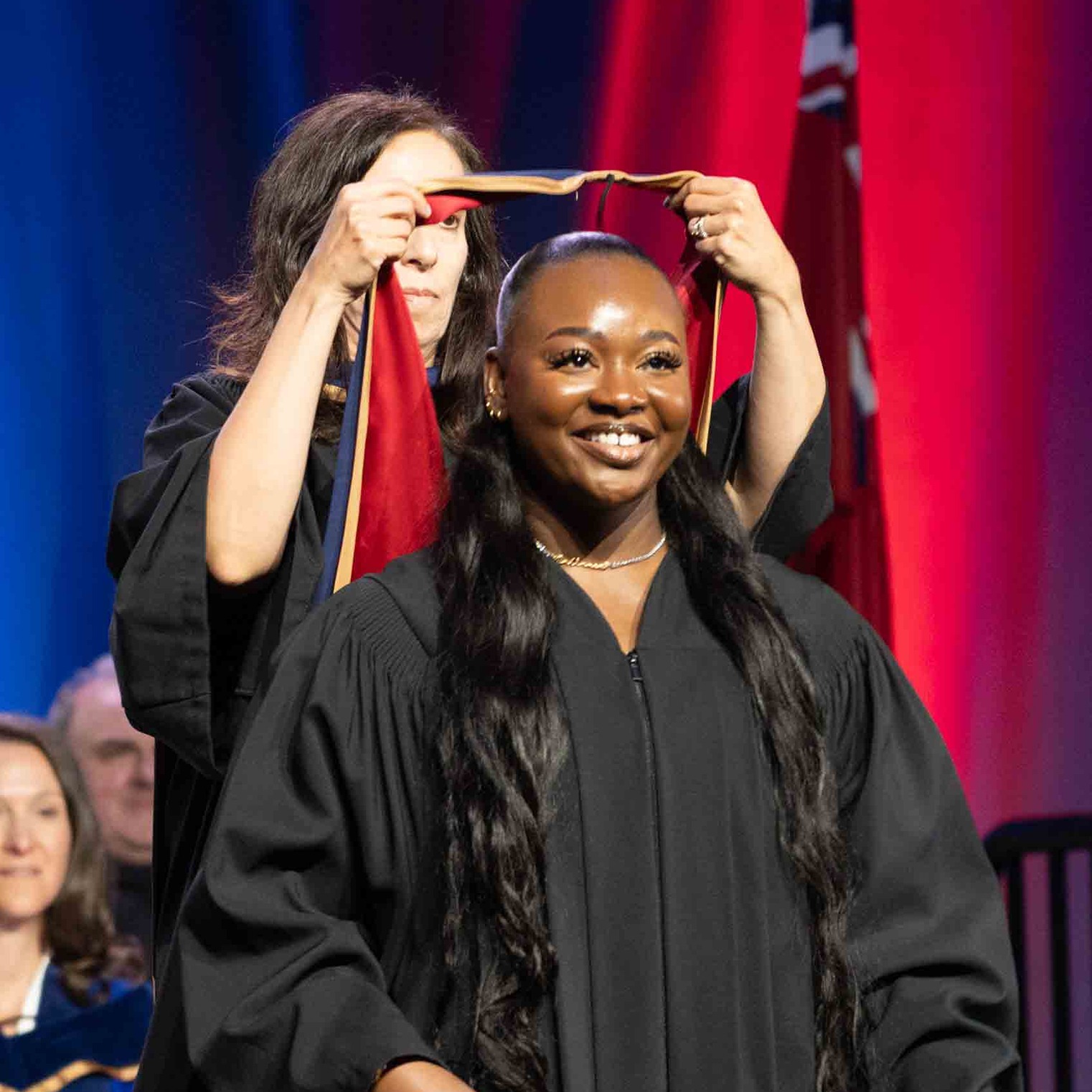 Nathania receives her graduation hood on stage at convocation