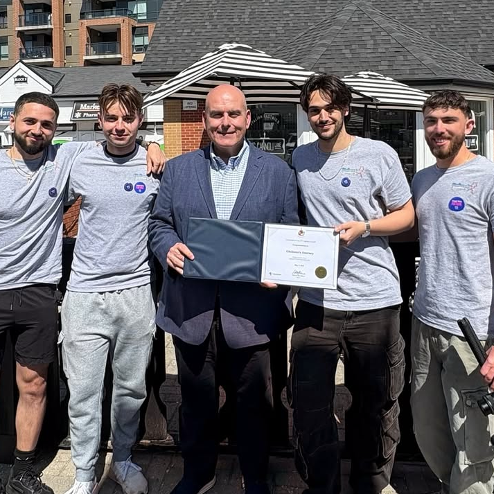 Giuliano poses with five men, including the mayor of Vaughan, with a certificate after completing his run
