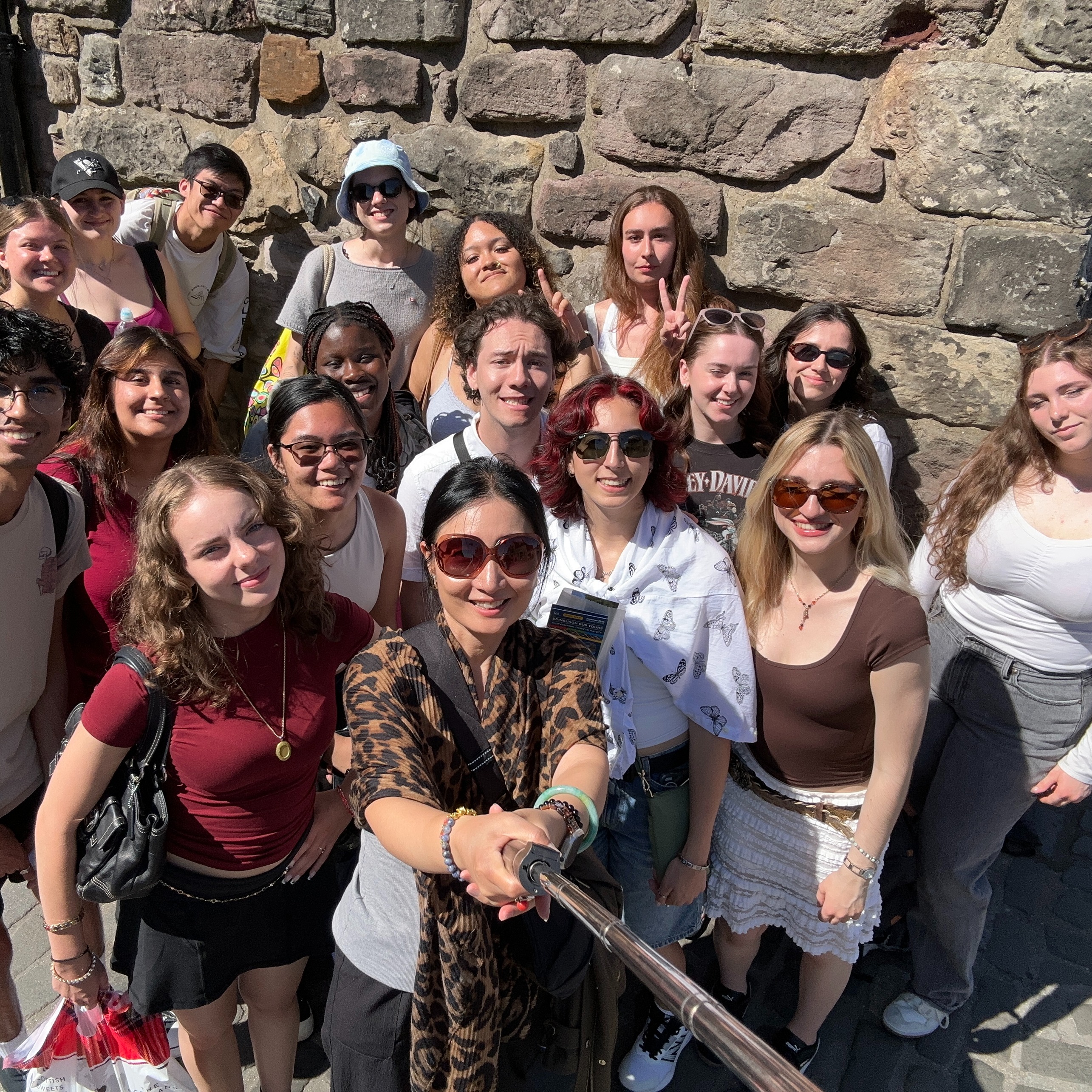The group poses in front of a stone wall in the U.K.
