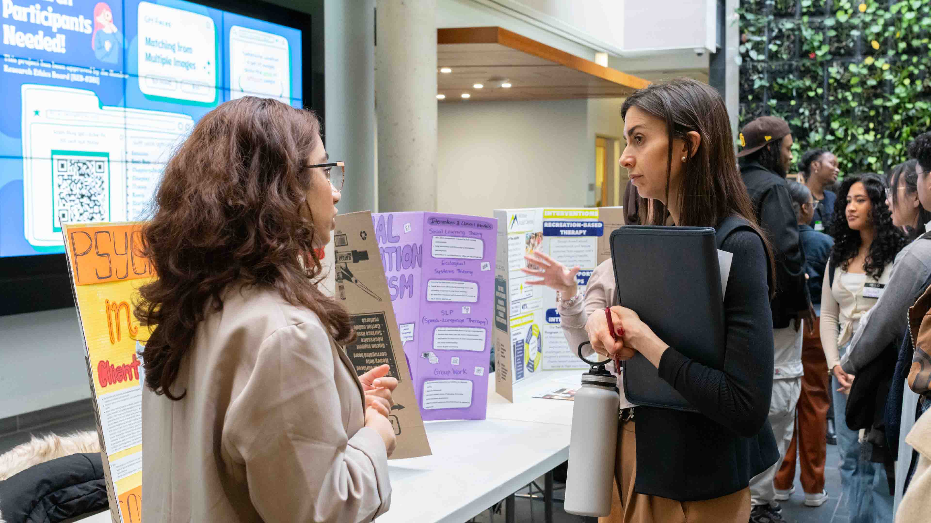 A student presents her poster project to Dr. Olivia Boukydis