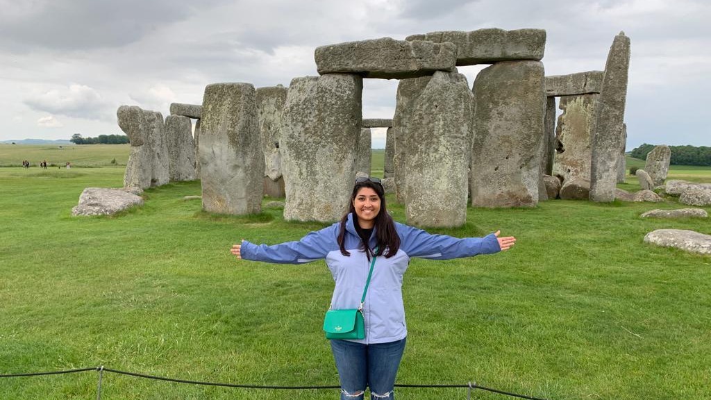 Skye Soobramanie stands in front of Stonehenge with her arms outstretched