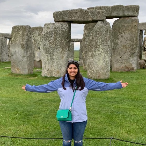 Skye Soobramanie stands in front of Stonehenge with her arms outstretched