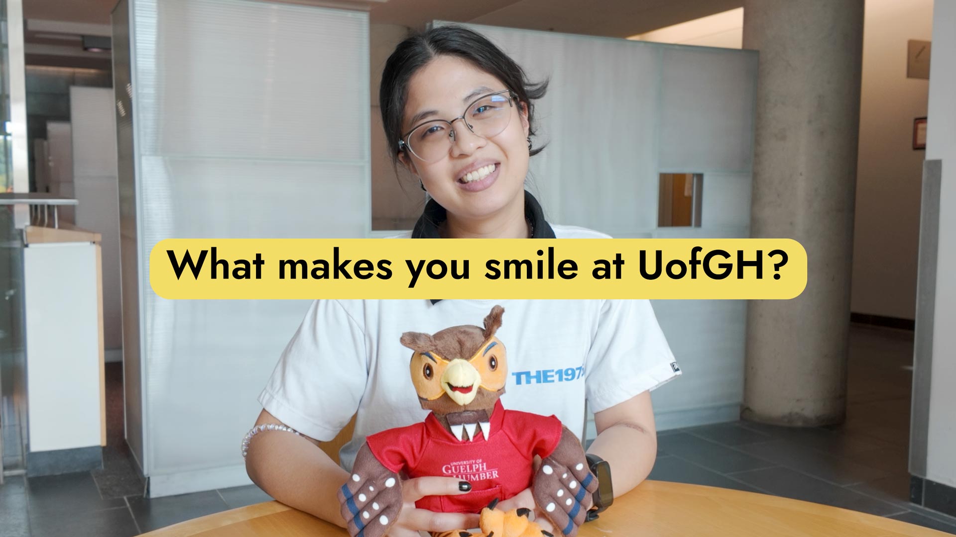 Student smiling and holding stuffy