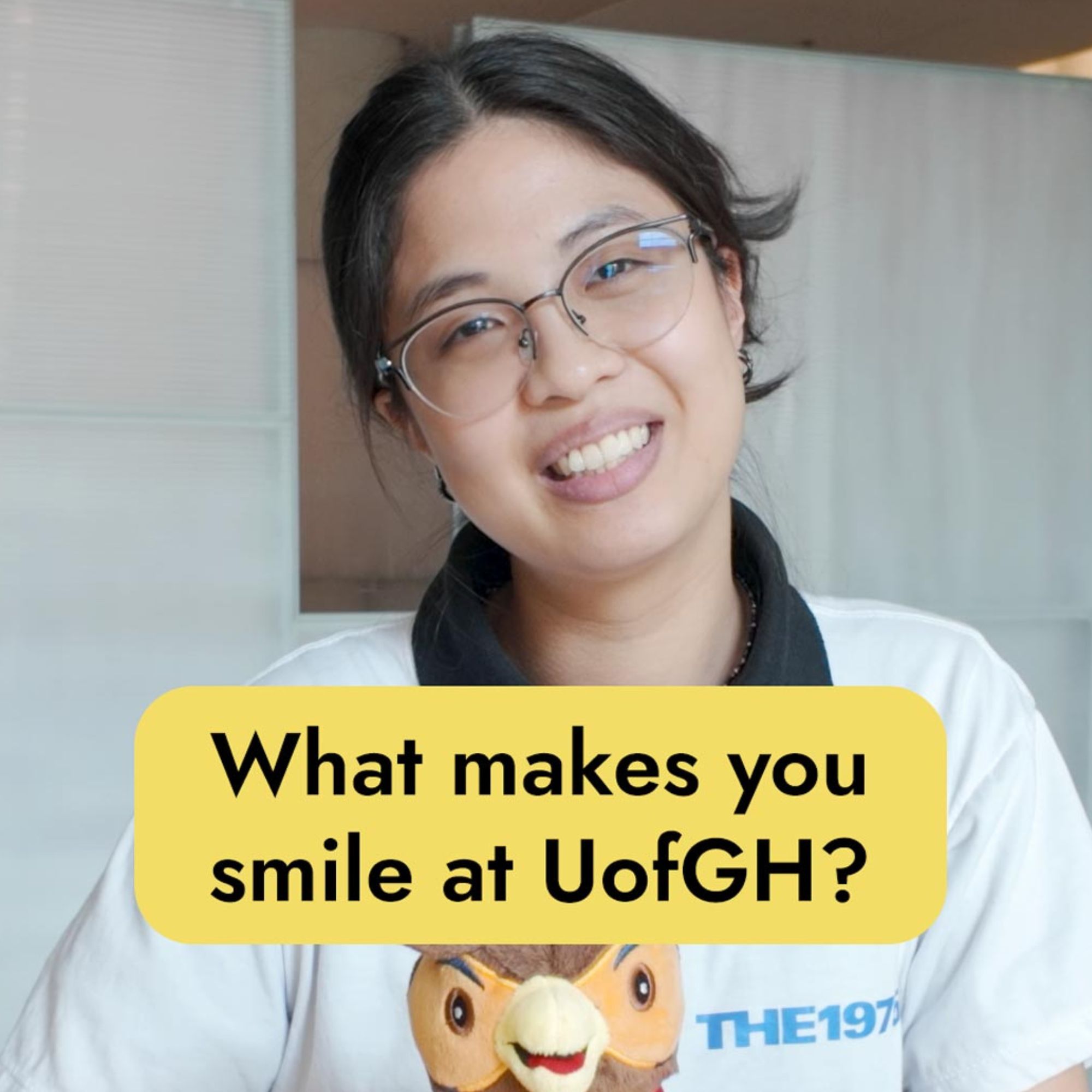 Student smiling and holding stuffy