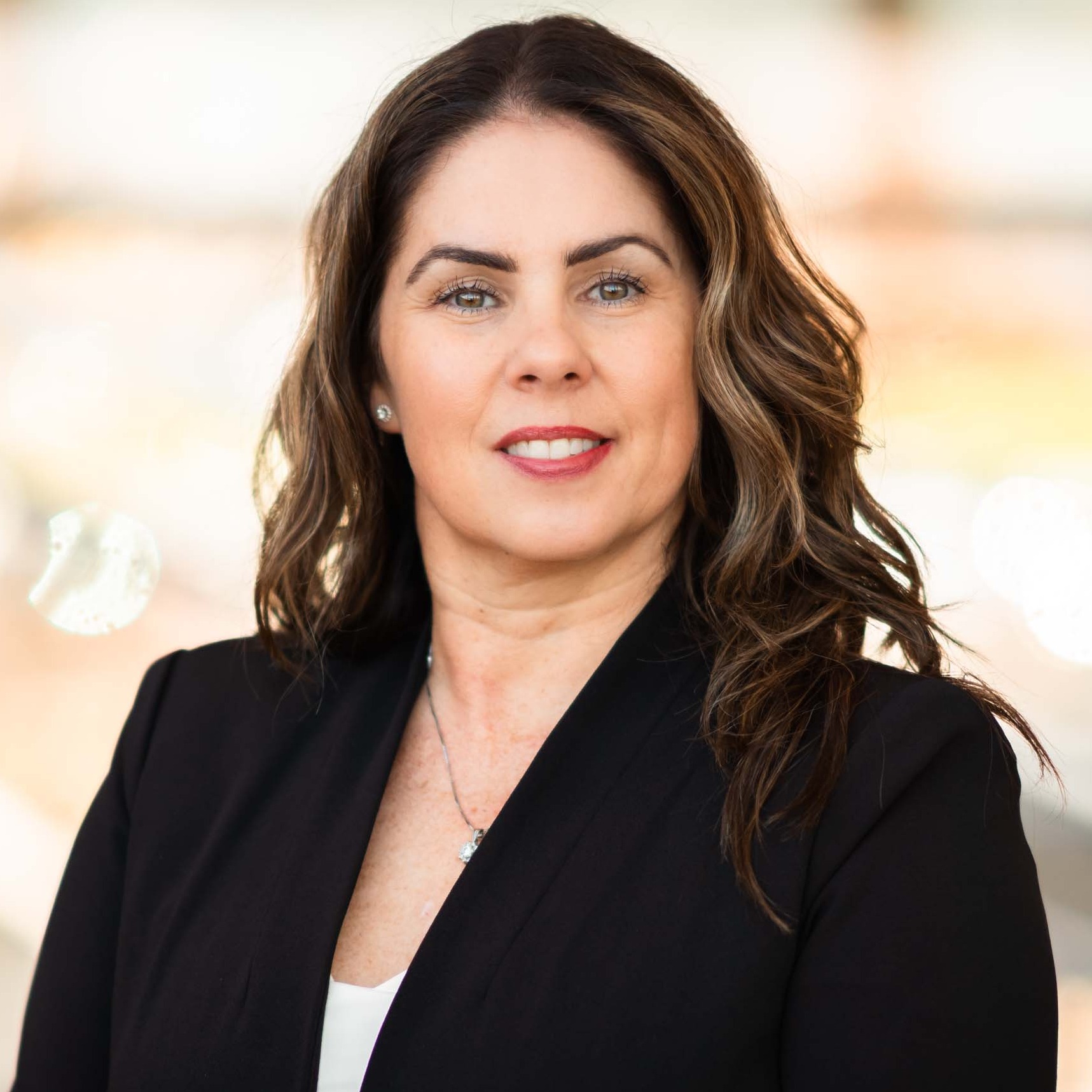 Danielle Pomeroy wears a black blazer, smiles at the camera