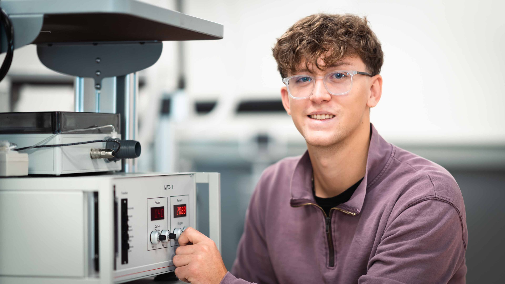 Nicolas Cyr holds a knob on a piece of lab equipment