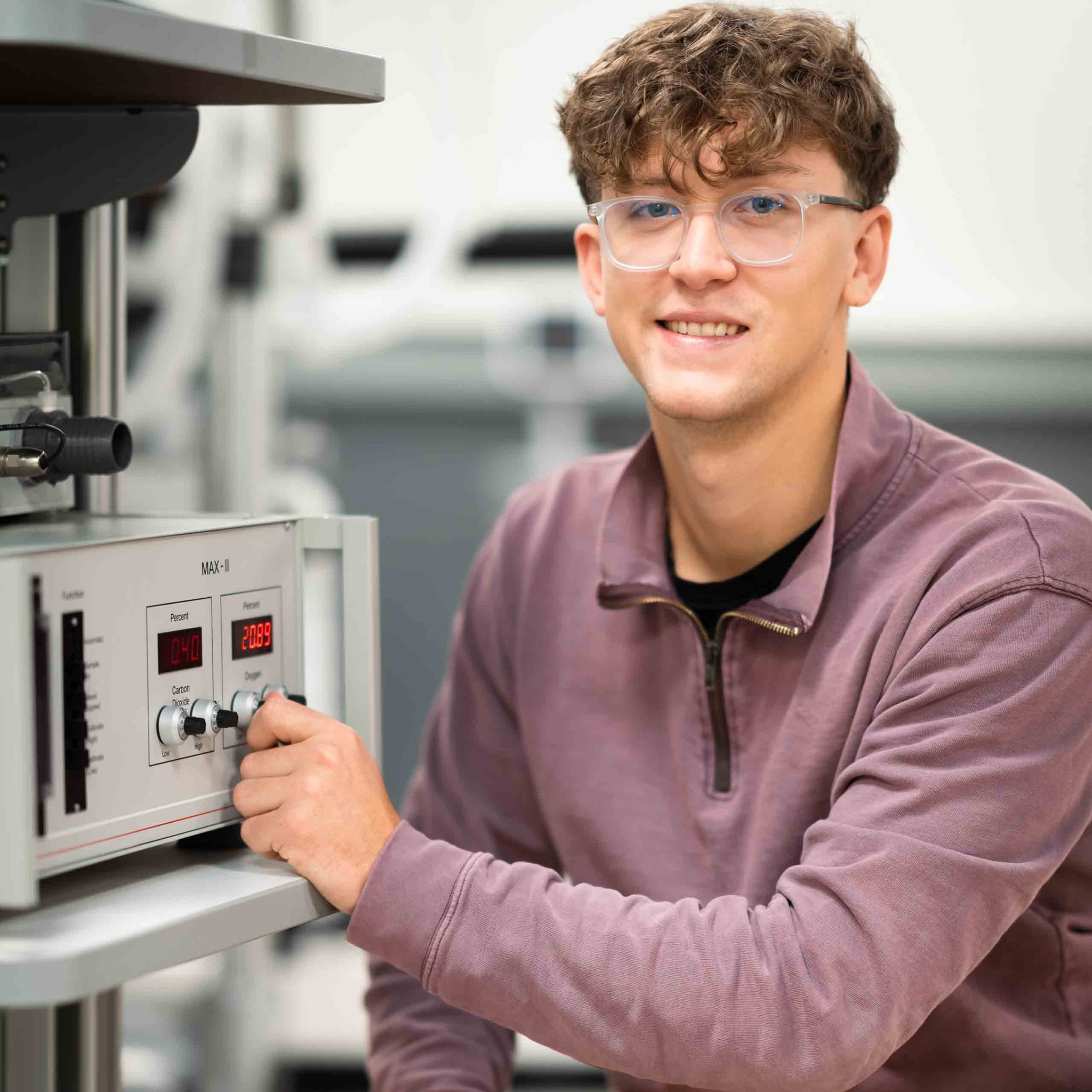 Nicolas Cyr holds a knob on a piece of lab equipment