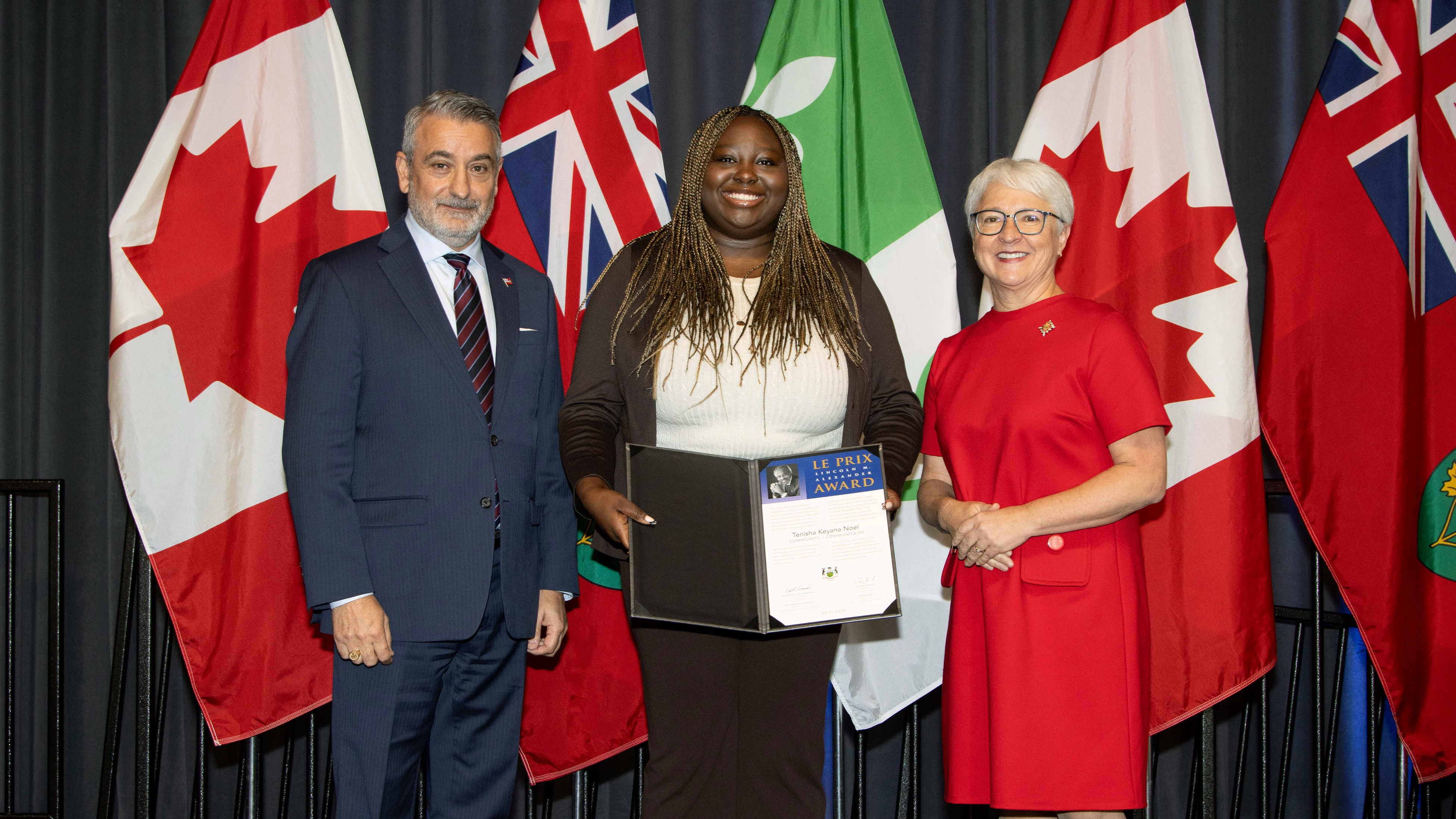 Tenisha Noel accepts the 2025 Lieutenant Governor&#039;s Lincoln M. Alexander Award, standing between two people f