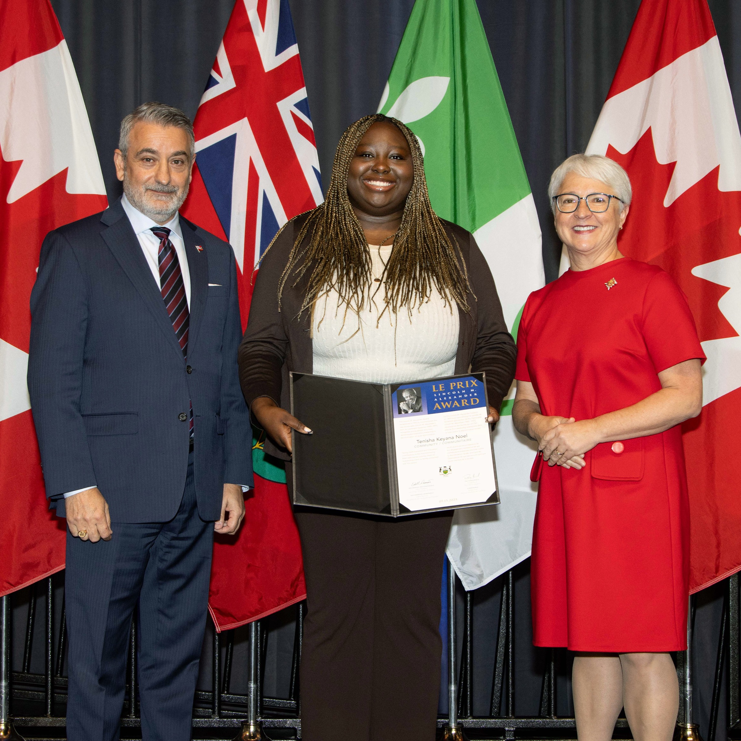 Tenisha Noel accepts the 2025 Lieutenant Governor&#039;s Lincoln M. Alexander Award, standing between two people f