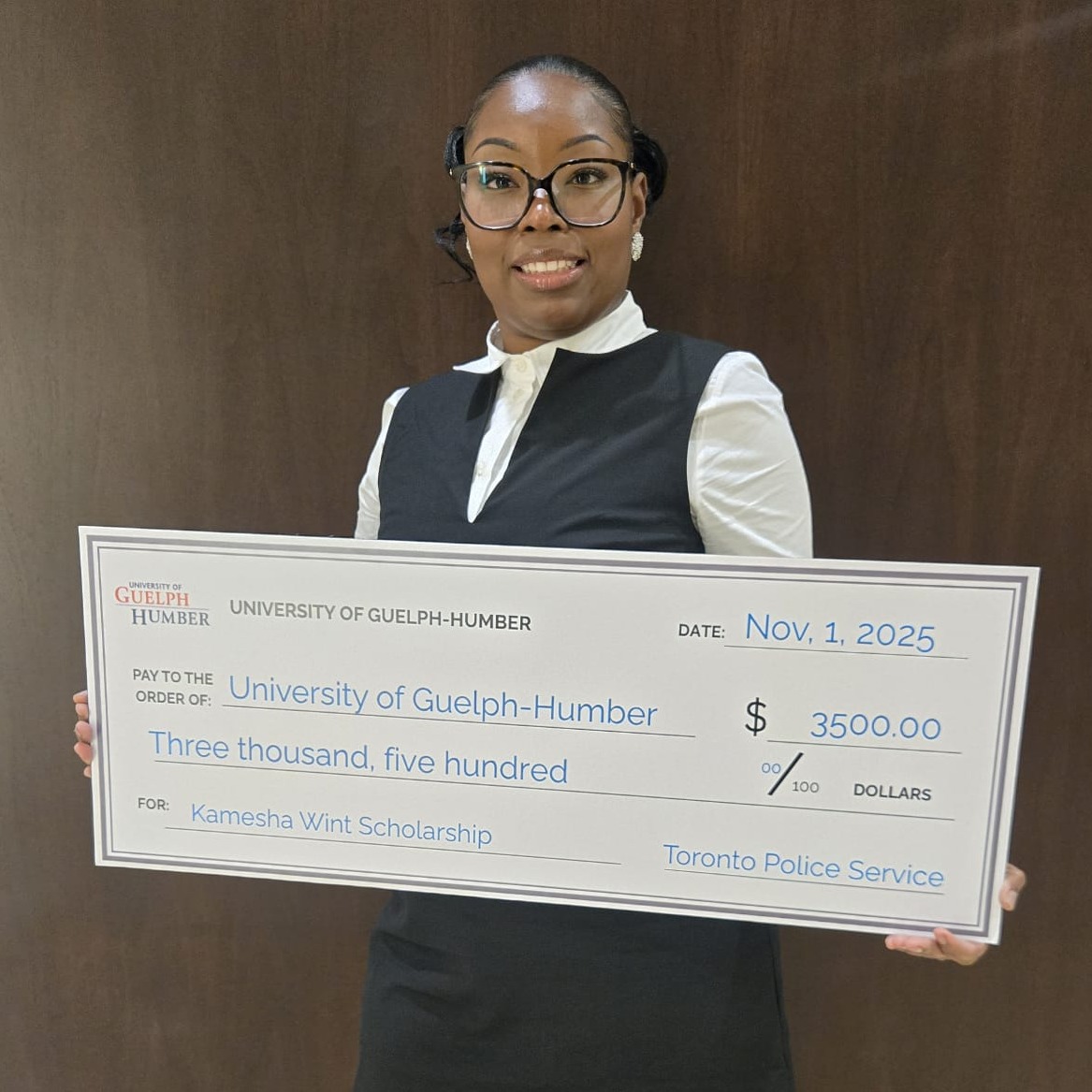 Kamesha Wint holds a big check with her scholarship dollar amount
