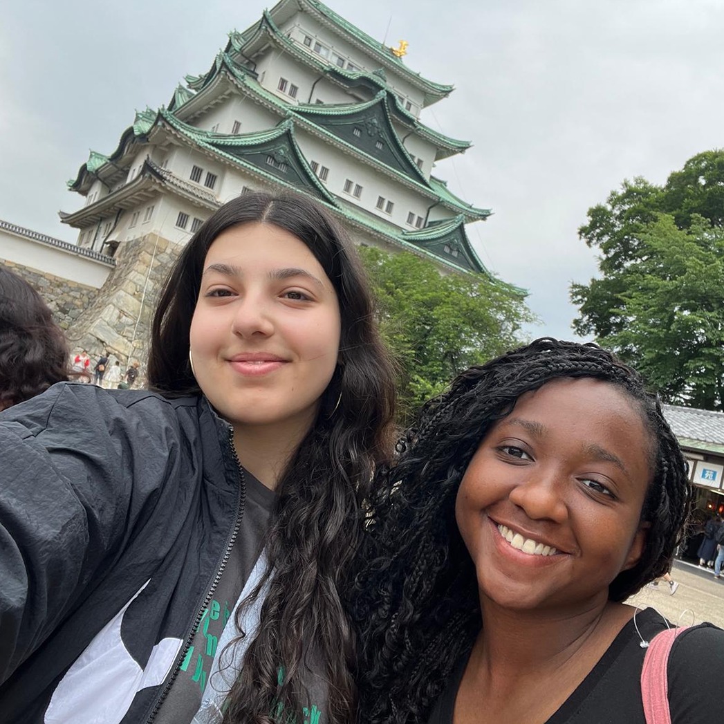 Krystal and Jasmin pose in front of a landmark in Japan