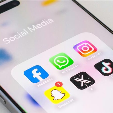 A phone shows a list of social media apps